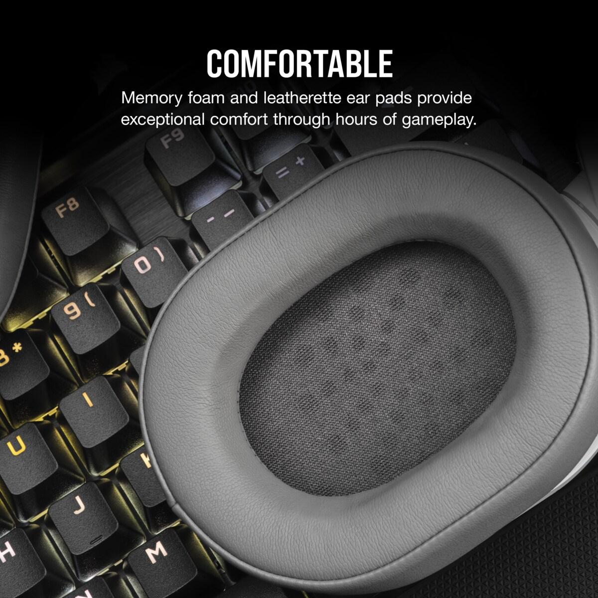 Nahaufnahme einer grauen Kopfhörer-Ohrmuschel auf einer Tastatur. Text lautet 'COMFORTABLE'.
