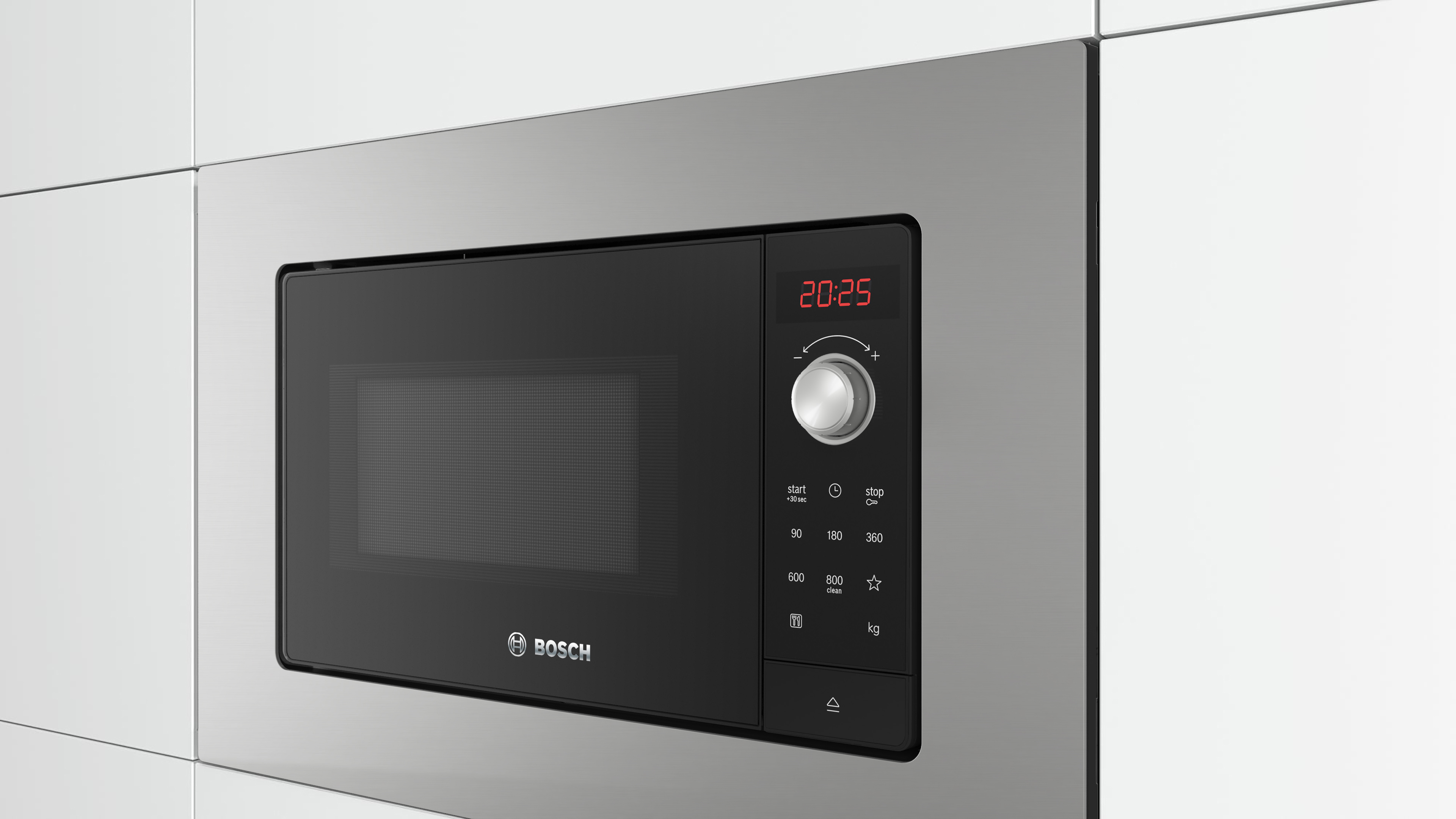 Horno microondas empotrado en un armario, frontal negro, marco plateado.