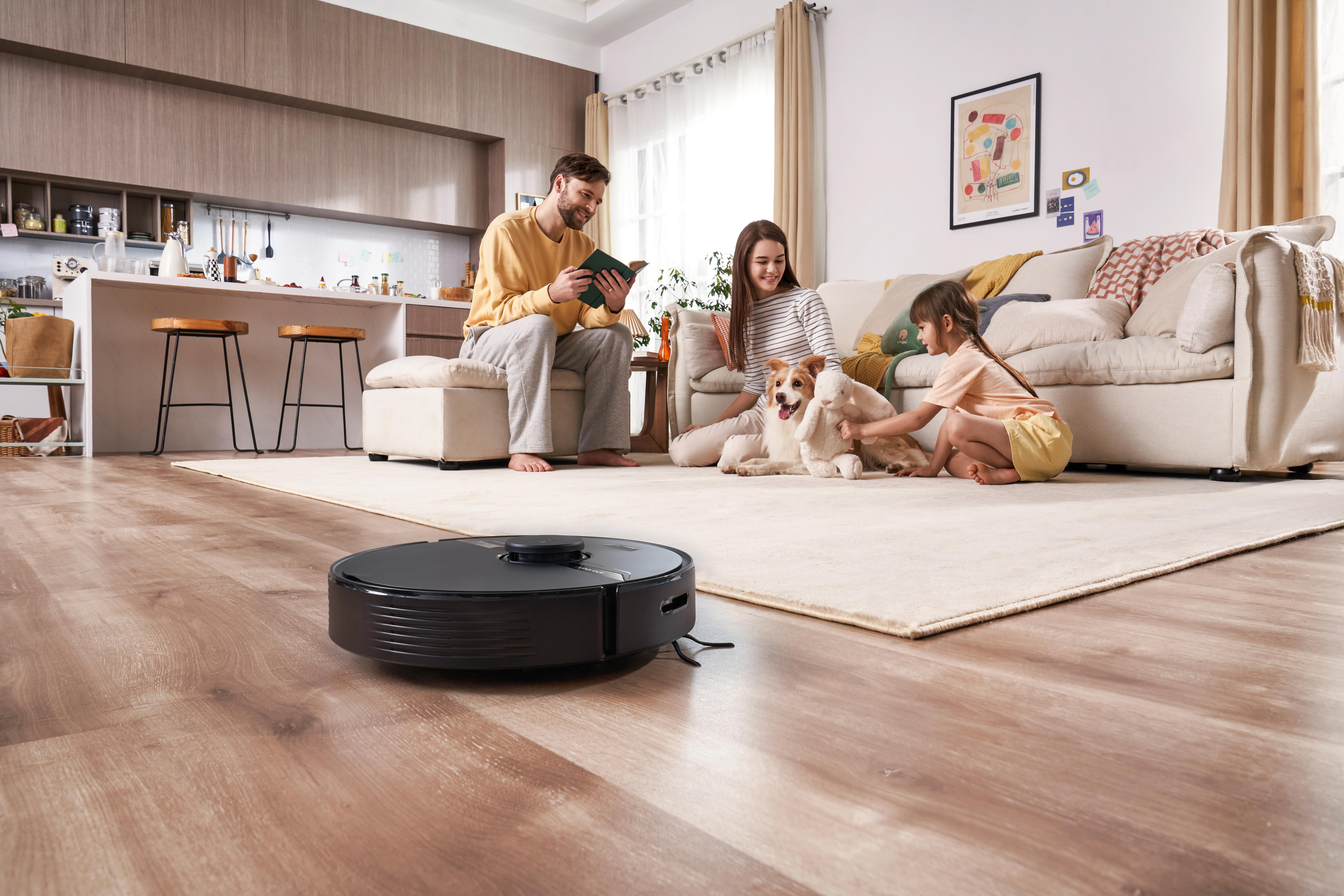 Familie in einem modernen Zuhause mit einem Roboterstaubsauger.