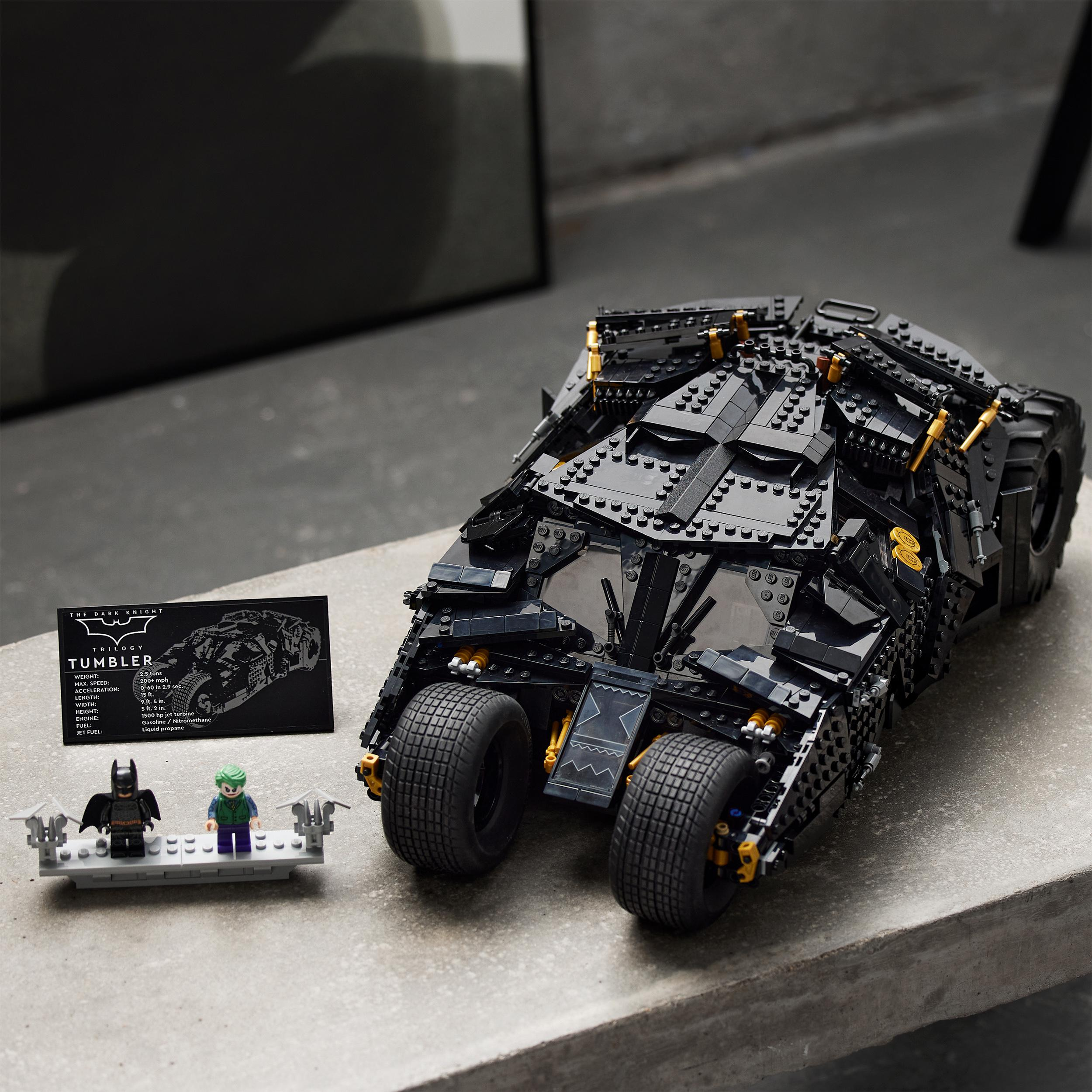 Ein schwarzes Lego Tumbler-Auto mit Batman- und Joker-Figuren steht auf einer Betonoberfläche.