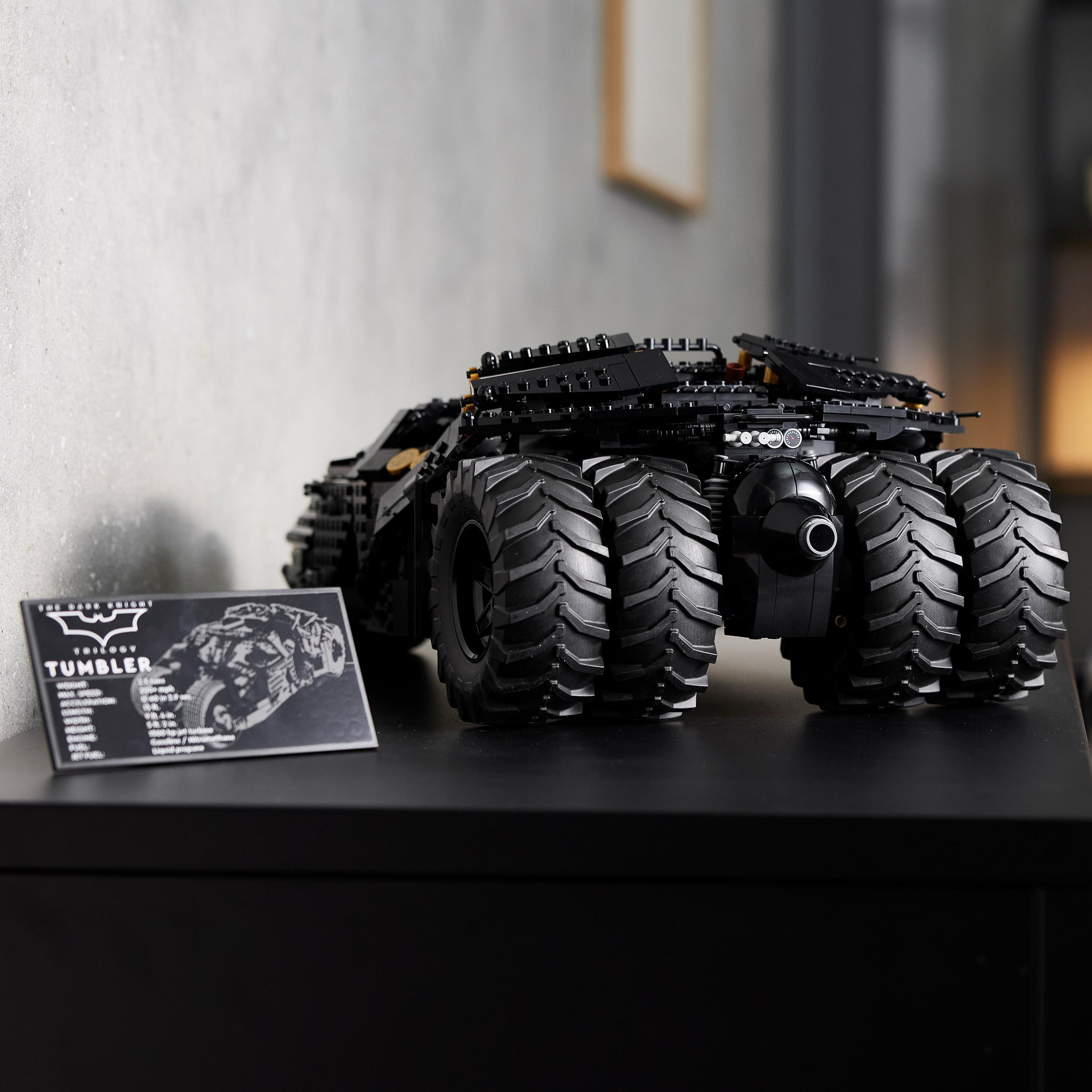 Ein schwarzes Lego Tumbler Modell auf einer schwarzen Oberfläche. Eine Karte mit Informationen zum Modell liegt daneben.