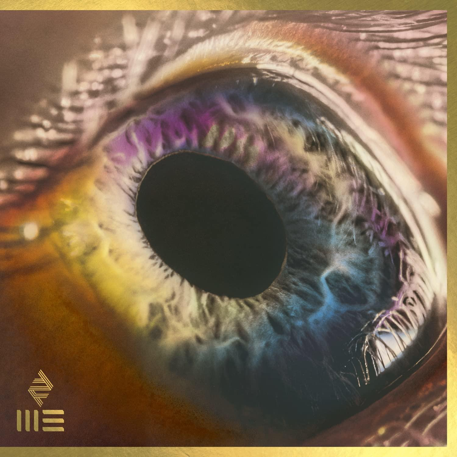 Album cover with a close-up of an eye. Rainbow colors in the iris, gold frame.