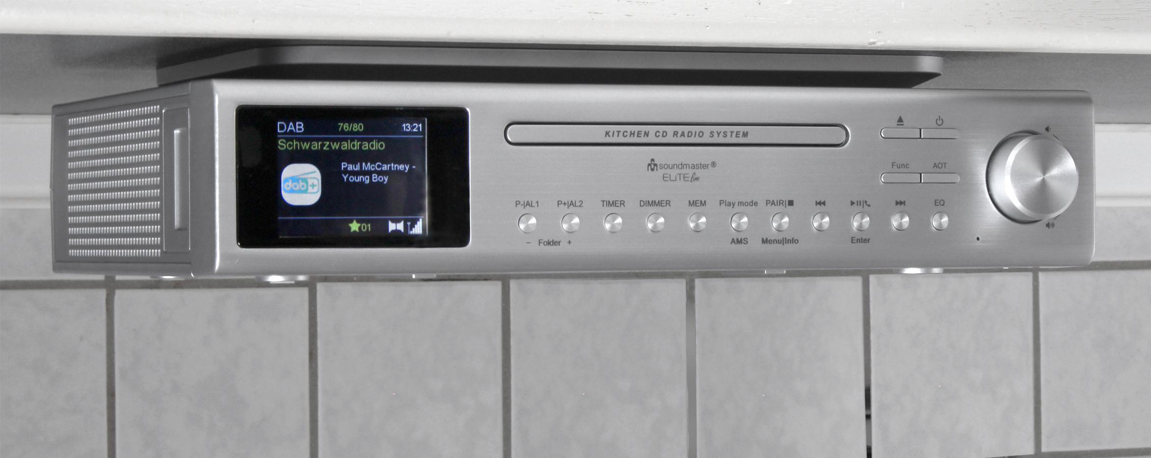 Ein silbernes Küchenradio mit einem Display, das einen Radiosender und Text anzeigt.