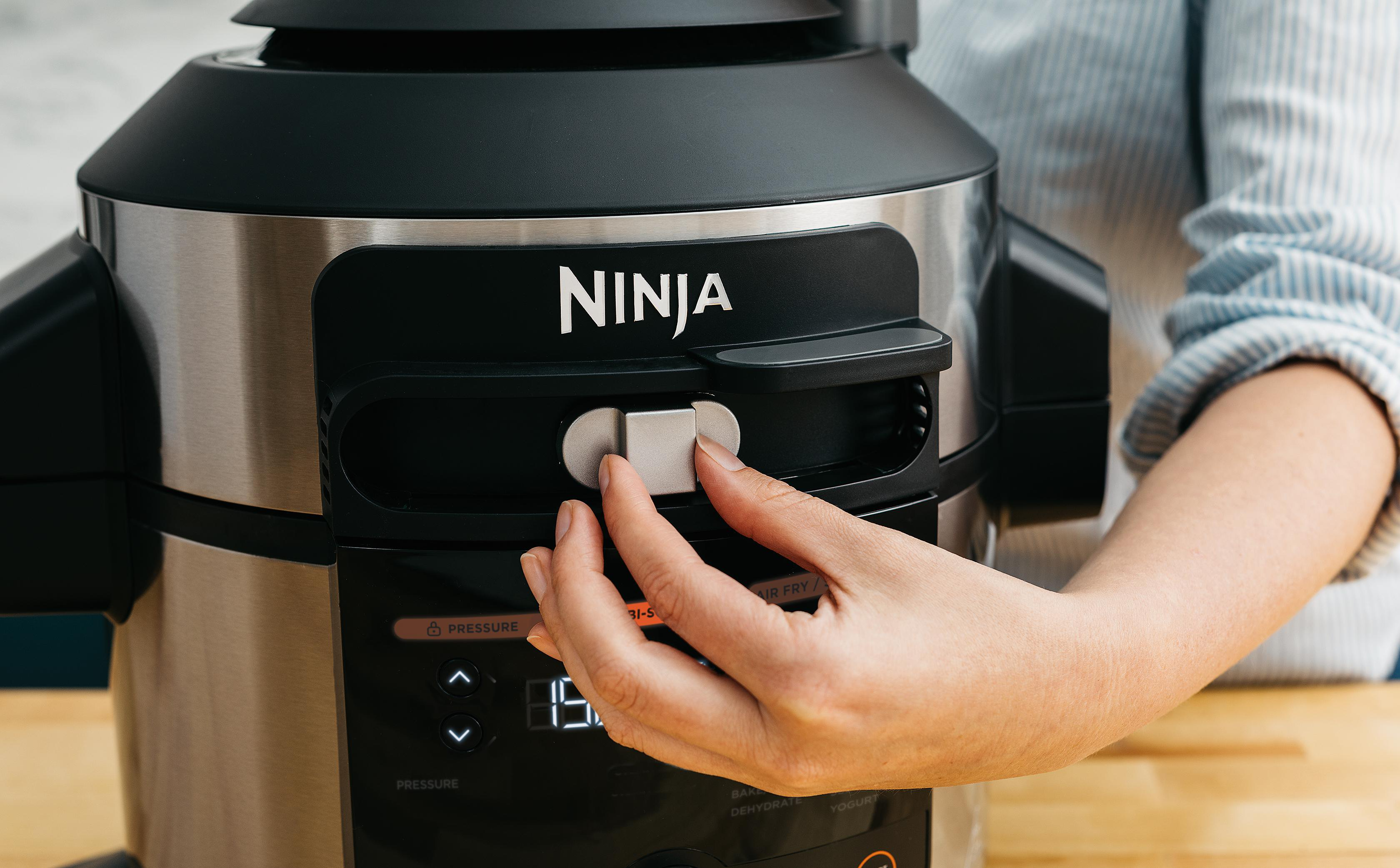 Eine Hand stellt das Druckventil an einem Ninja Multikocher-Gerät ein.