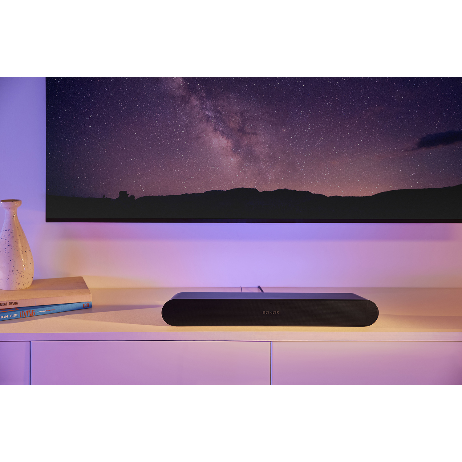 Soundbar Sonos su una superficie bianca di fronte a una TV.