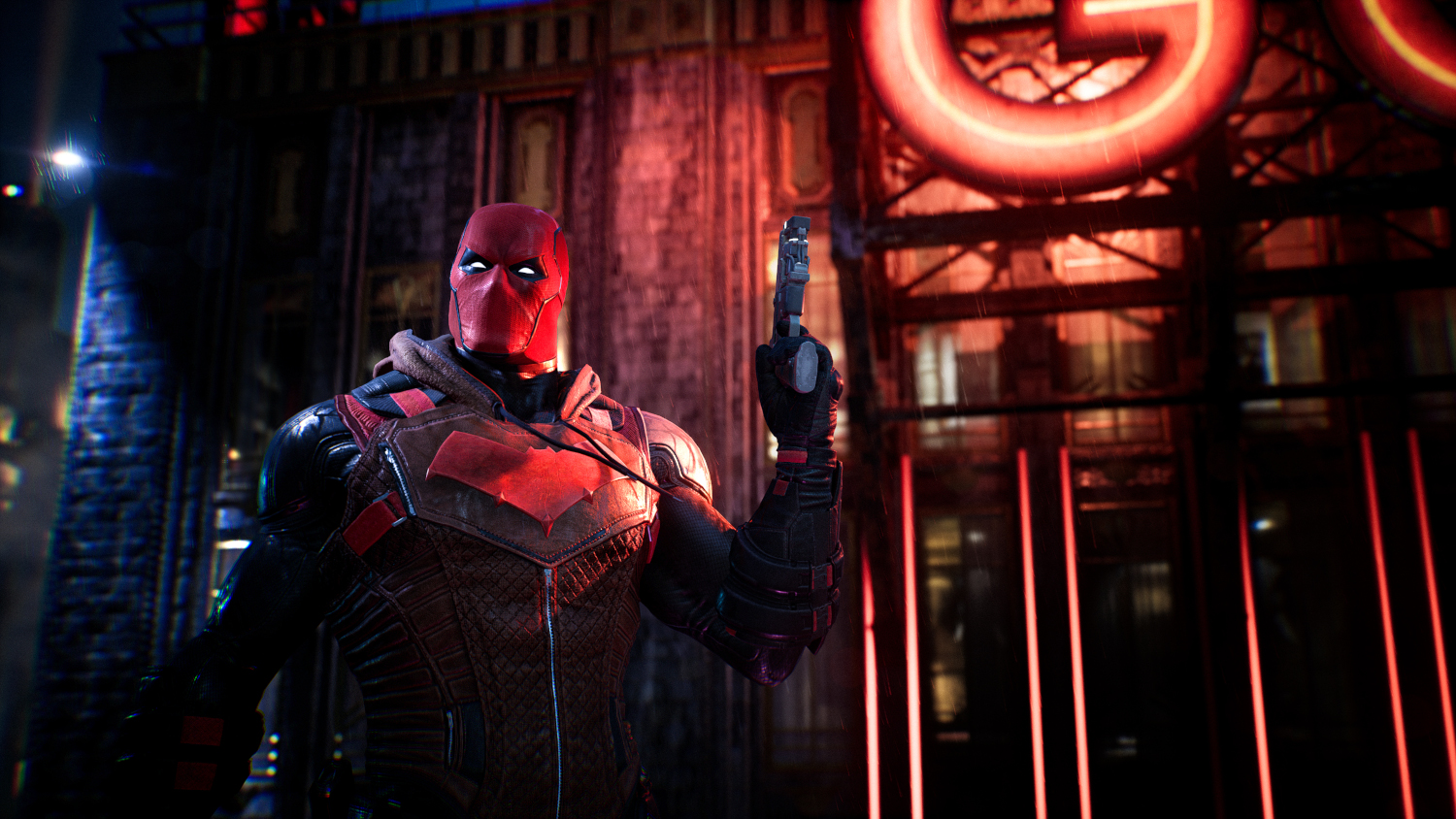 Red Hood uit Gotham Knights die een geweer voor een gebouw vasthoudt.