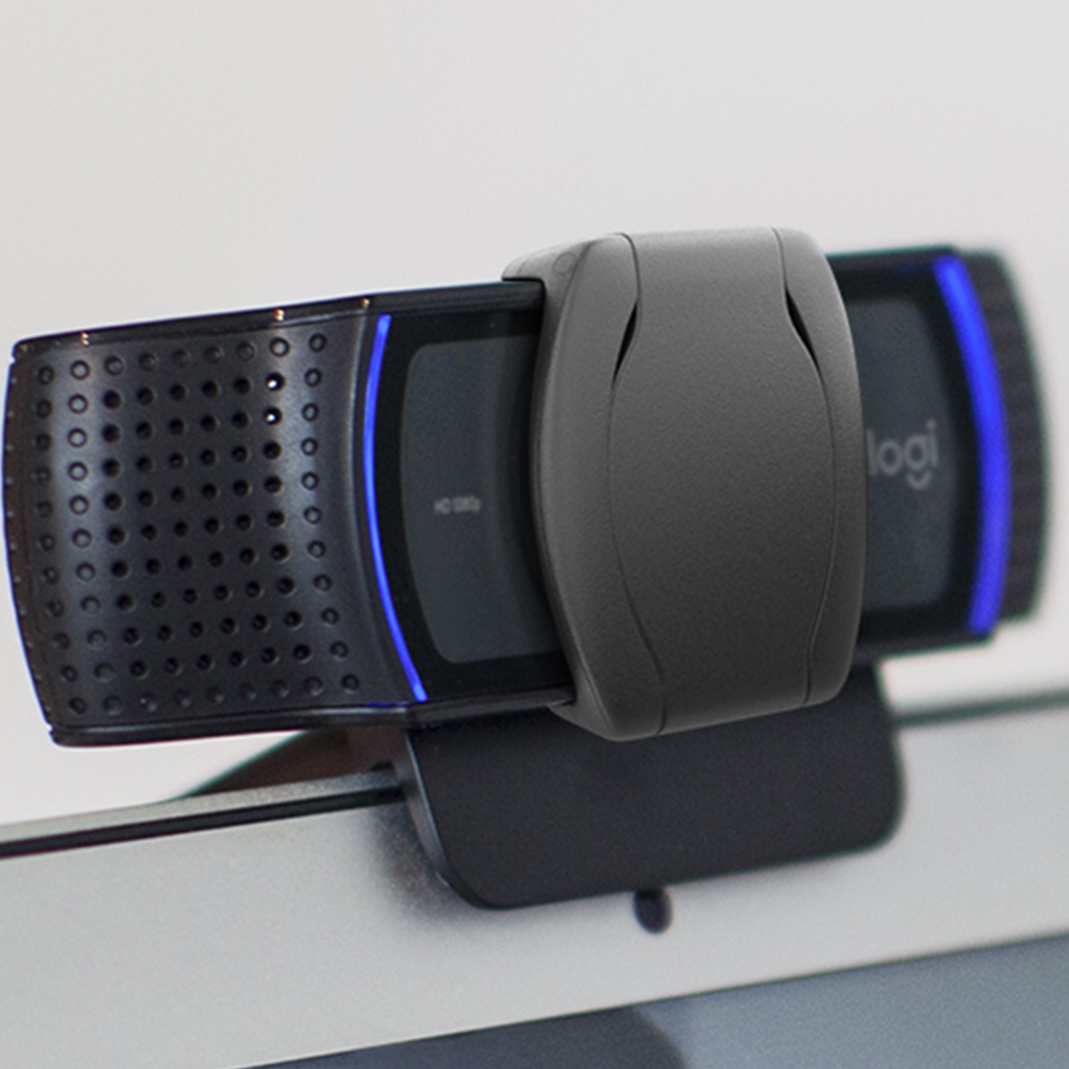Black webcam on a laptop screen, with blue lights and the logi logo.