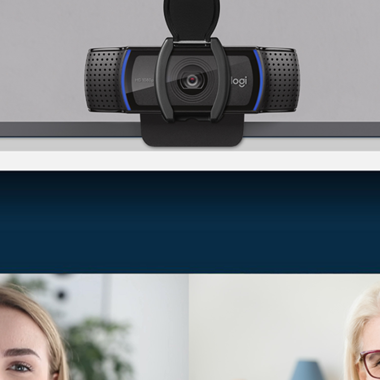 Webcam with a black and blue design, on a white shelf. Two women in the background are talking.