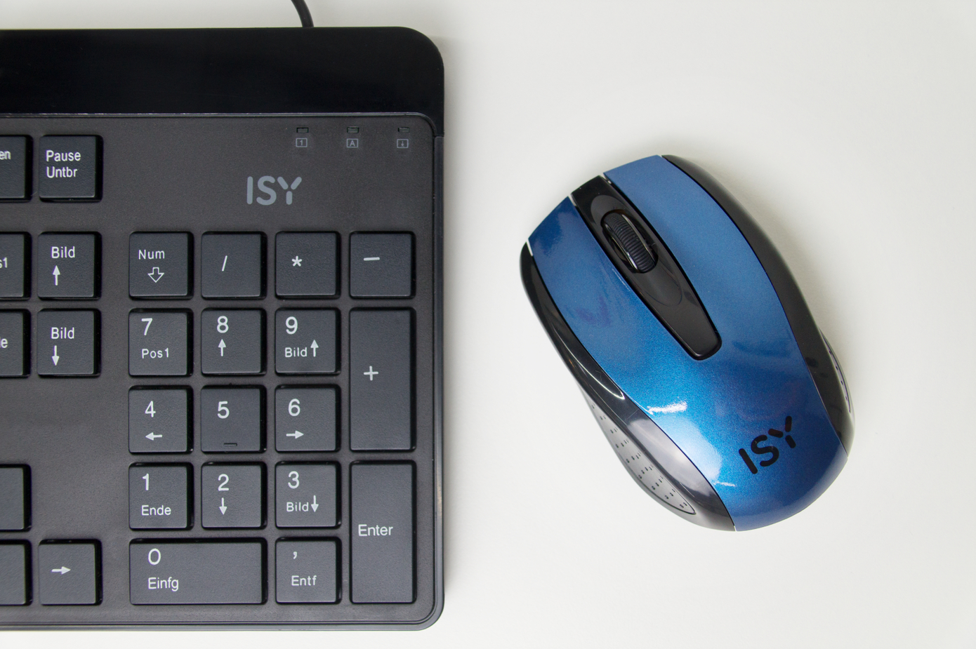 Eine schwarze Tastatur und eine blaue Maus auf einer weißen Oberfläche. Die Tastatur hat einen Ziffernblock. Die Maus hat ISY-Logo.