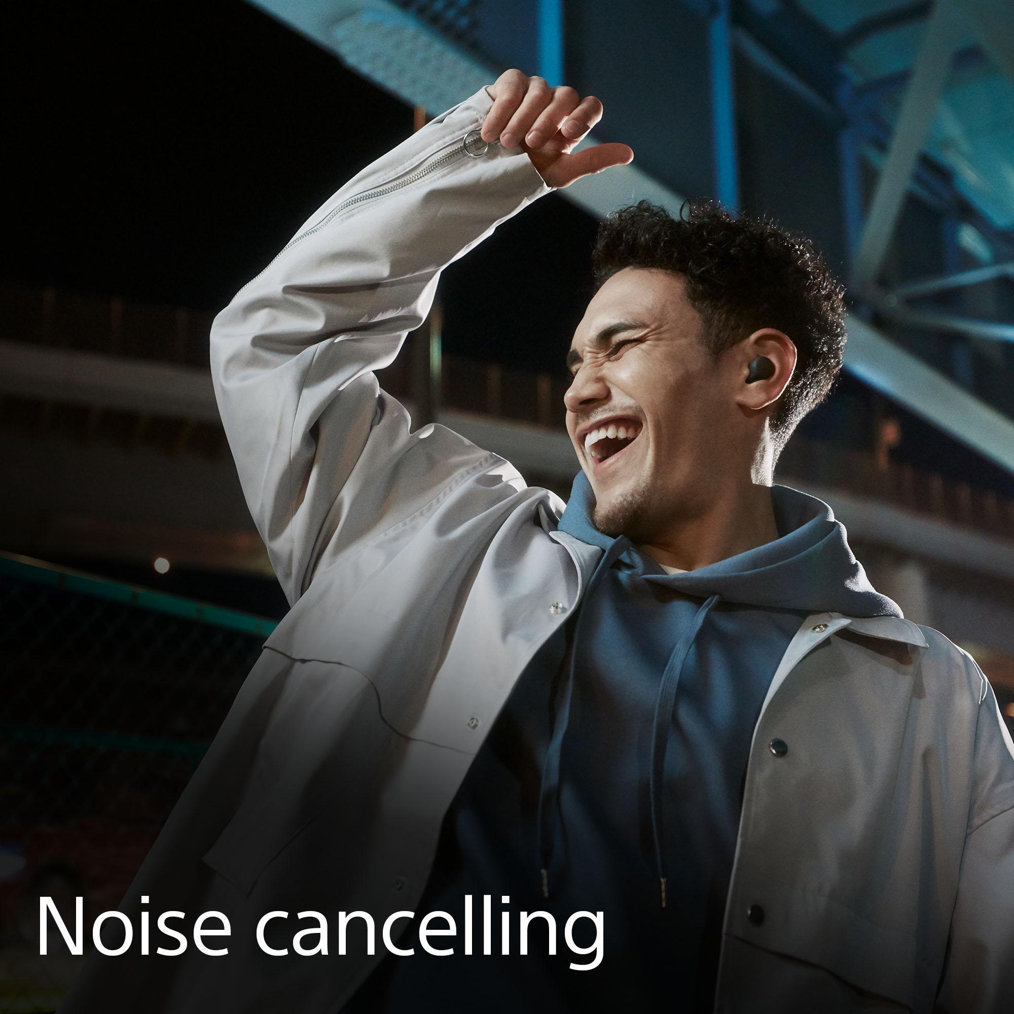 Ein Mann lächelt mit Kopfhörern. Der Text 'Noise cancelling' befindet sich unten im Bild.