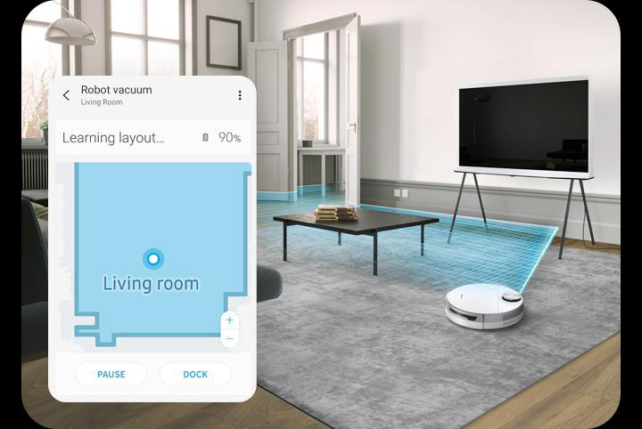 Smartphone mit App zeigt Wohnzimmerkarte, Roboter-Staubsauger reinigt Bereich.