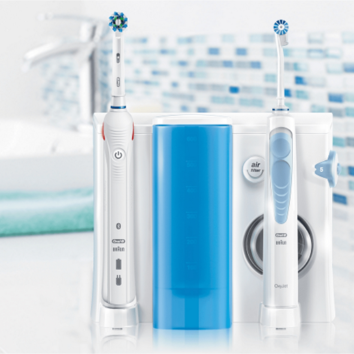 Dos cepillos de dientes eléctricos blancos y un recipiente de agua azul.