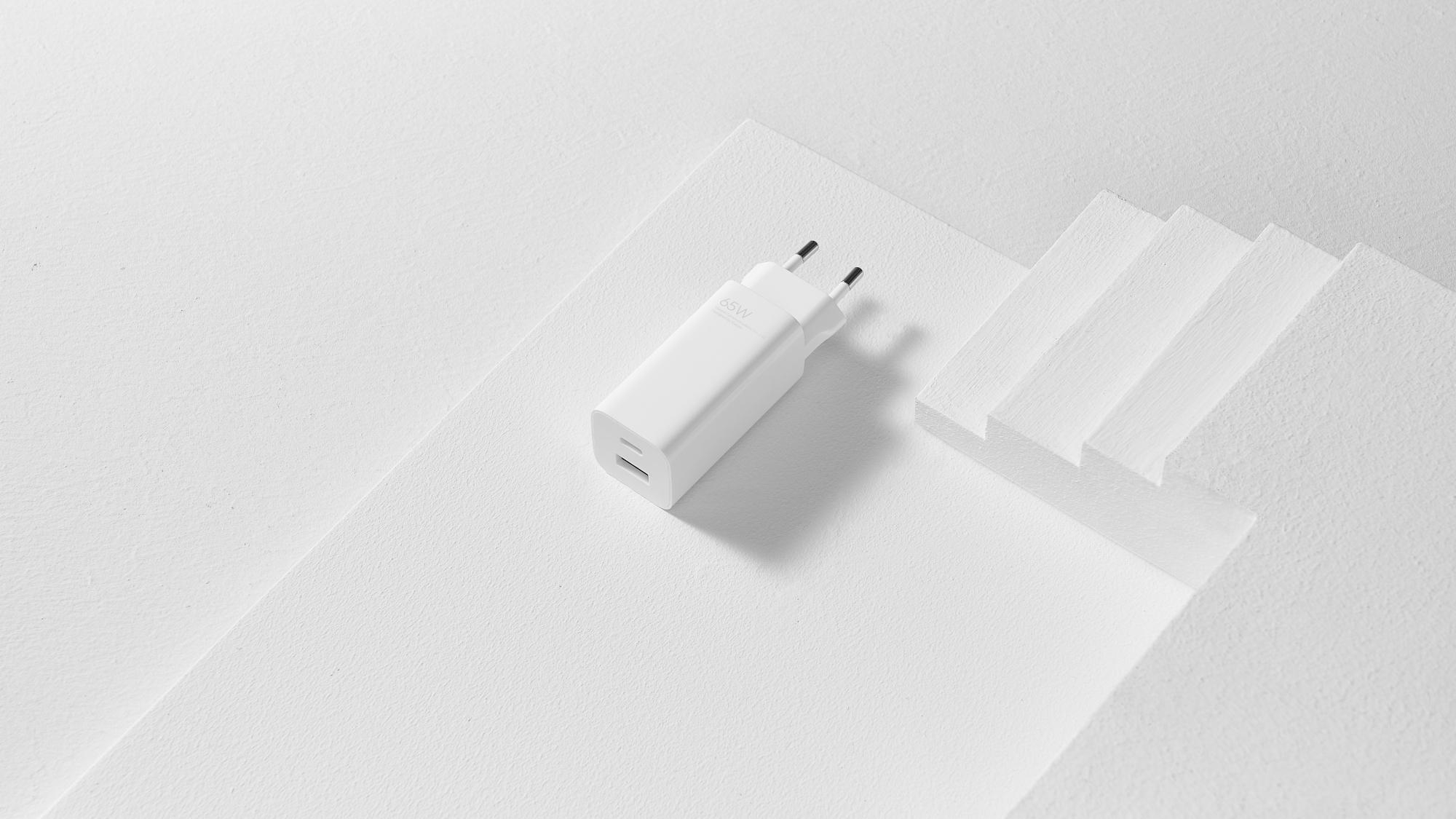 Weißes Ladegerät mit zwei USB-Anschlüssen auf weißer Oberfläche.