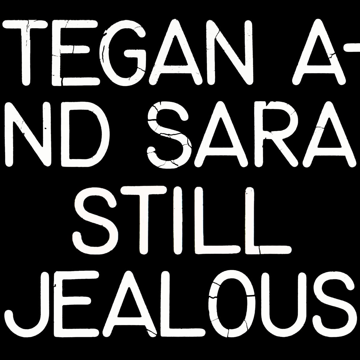 Szöveg fekete háttéren: „TEGAN AND SARA STILL JEALOUS” fehér, repedezett betűtípussal.