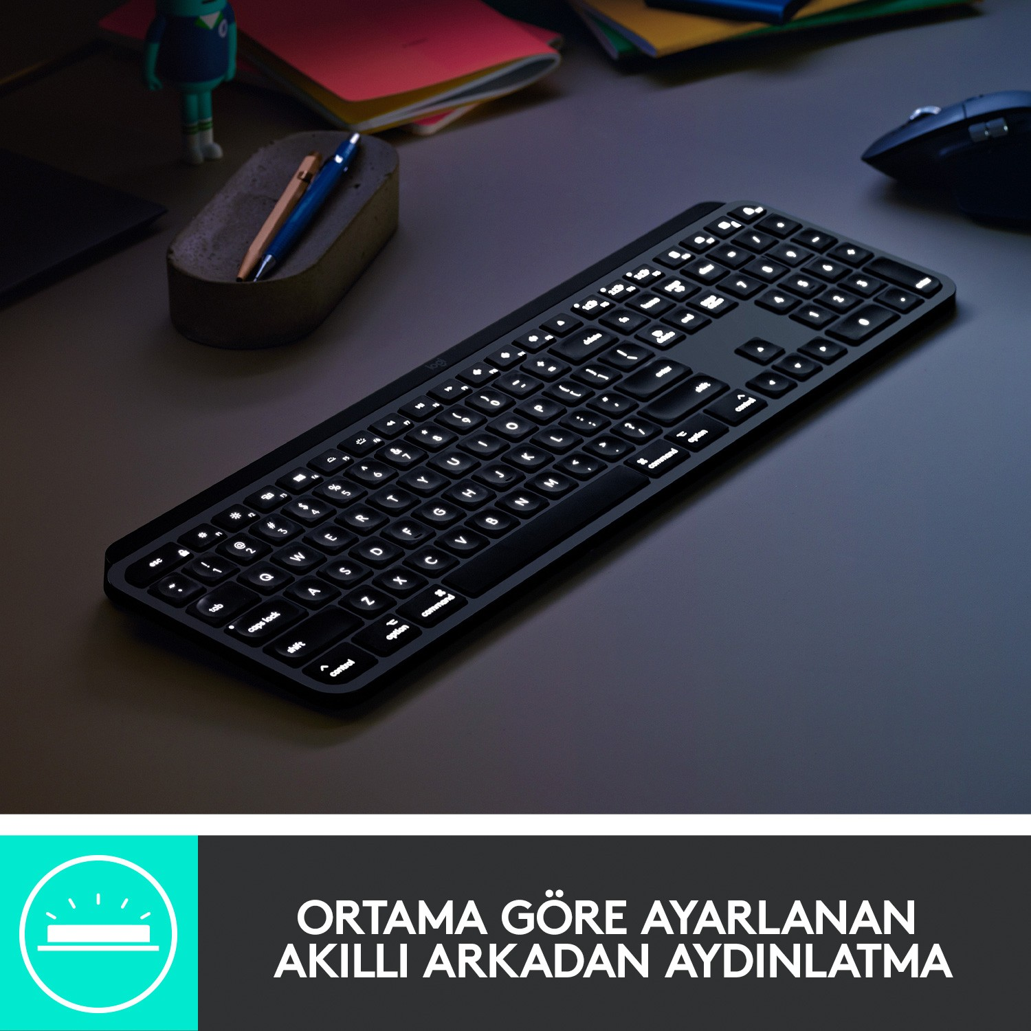 Karanlık bir yüzey üzerinde, Logitech logosu ve metni olan, aydınlatmalı tuşlara sahip siyah bir klavye.