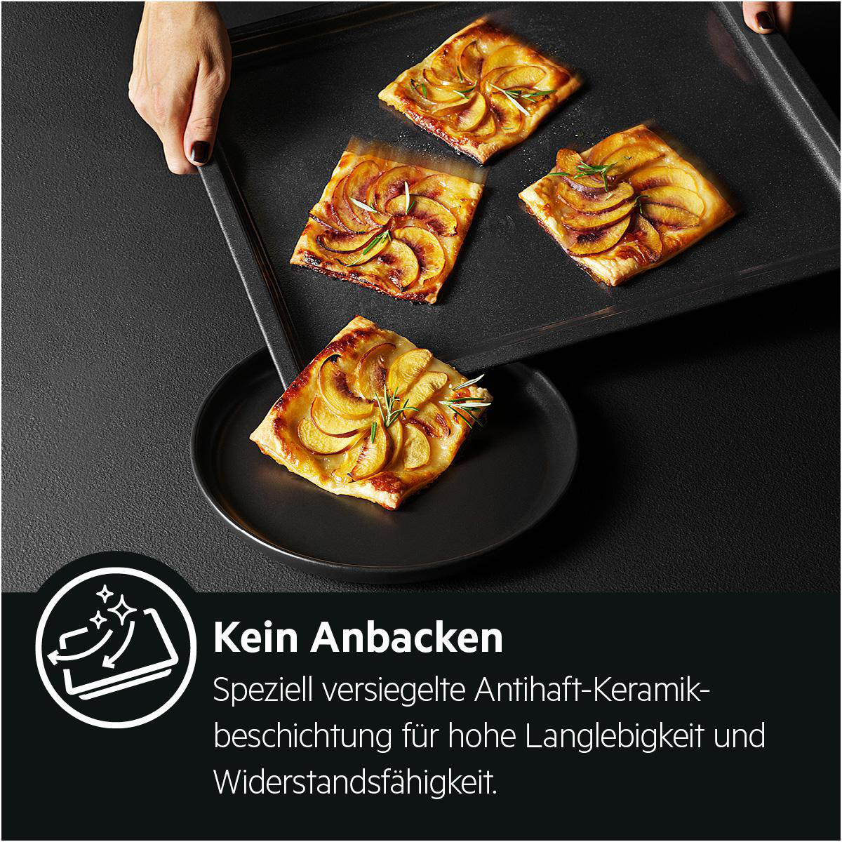 Gebackene Apfeltarte auf einem schwarzen Backblech. Text auf dem Blech: 'Kein Anbacken'.