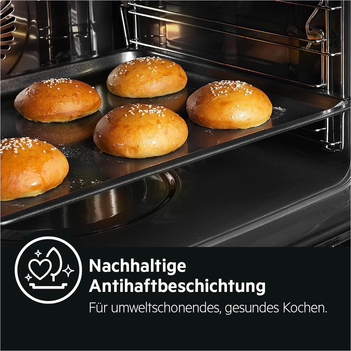 Sechs goldbraune Hamburgerbrötchen auf einem schwarzen Backblech im Ofen.