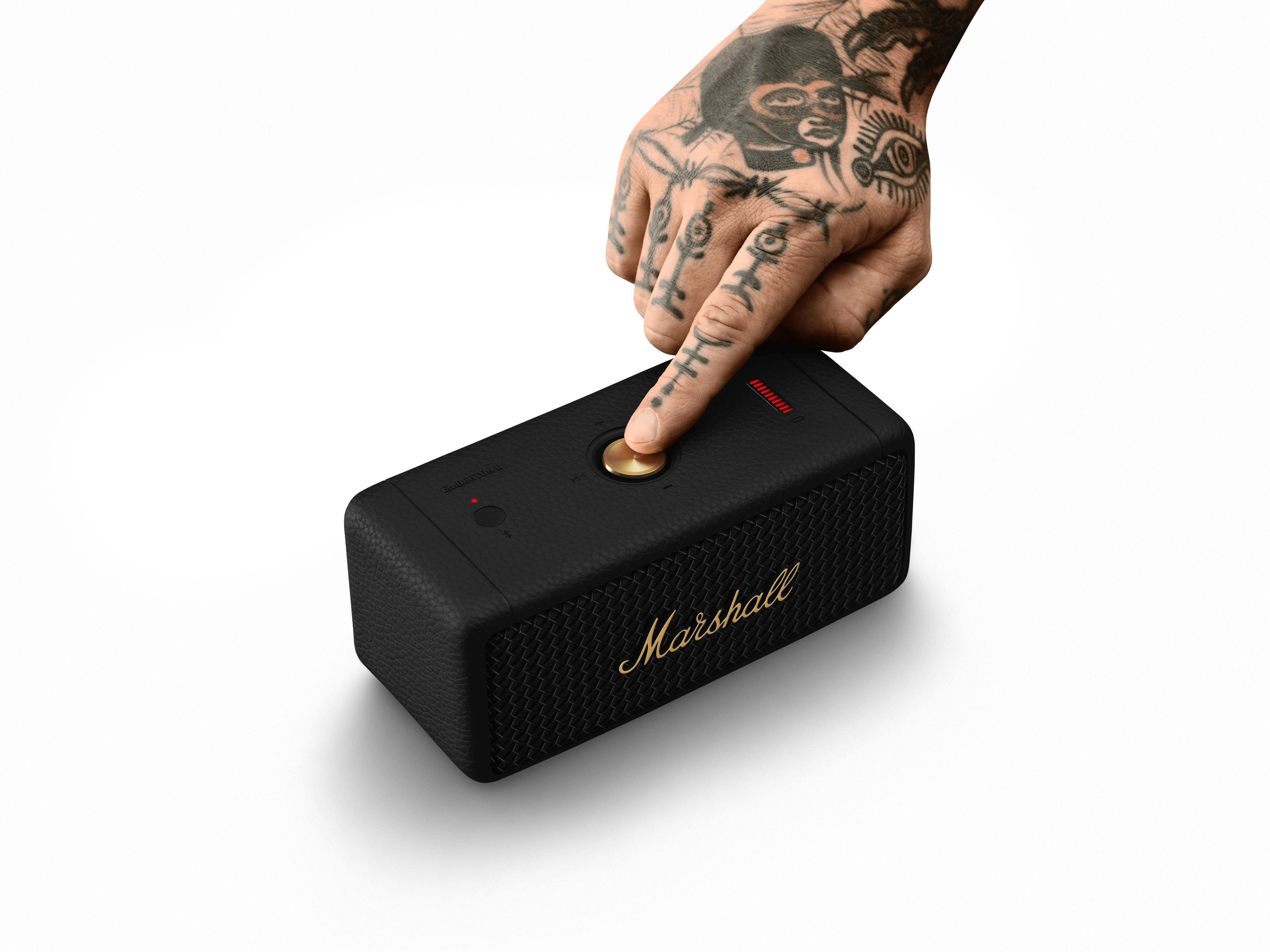 Schwarzer Marshall-Lautsprecher mit goldenem Knopf, rotem Licht und Hand.