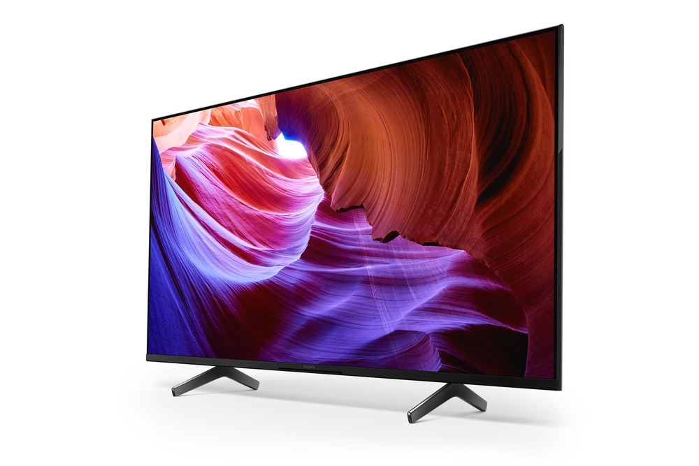 Un televisor de pantalla plana grande con una escena de cañón rojo y morado.
