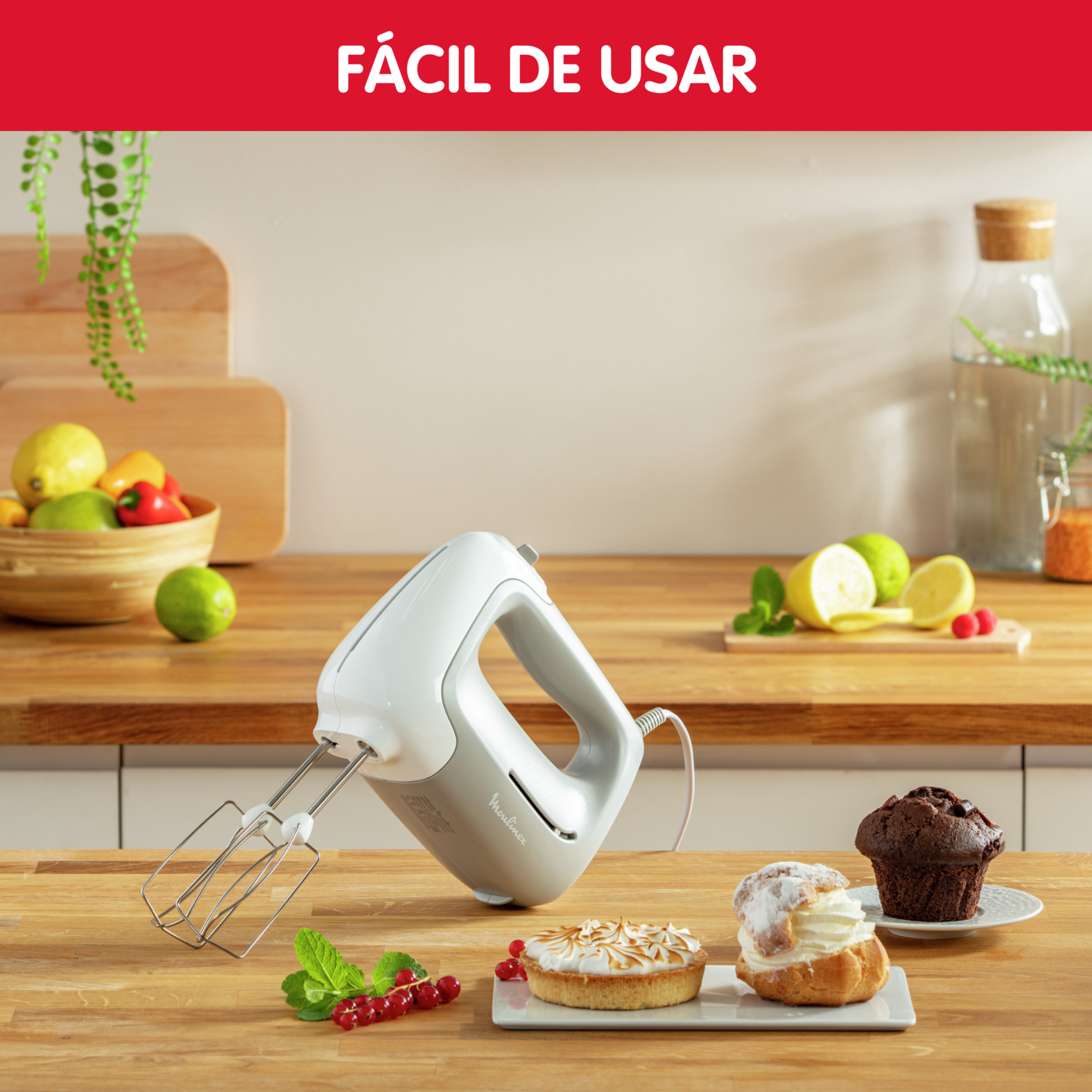 Batidora de mano con pasteles en superficie de madera; texto: Fácil de usar.