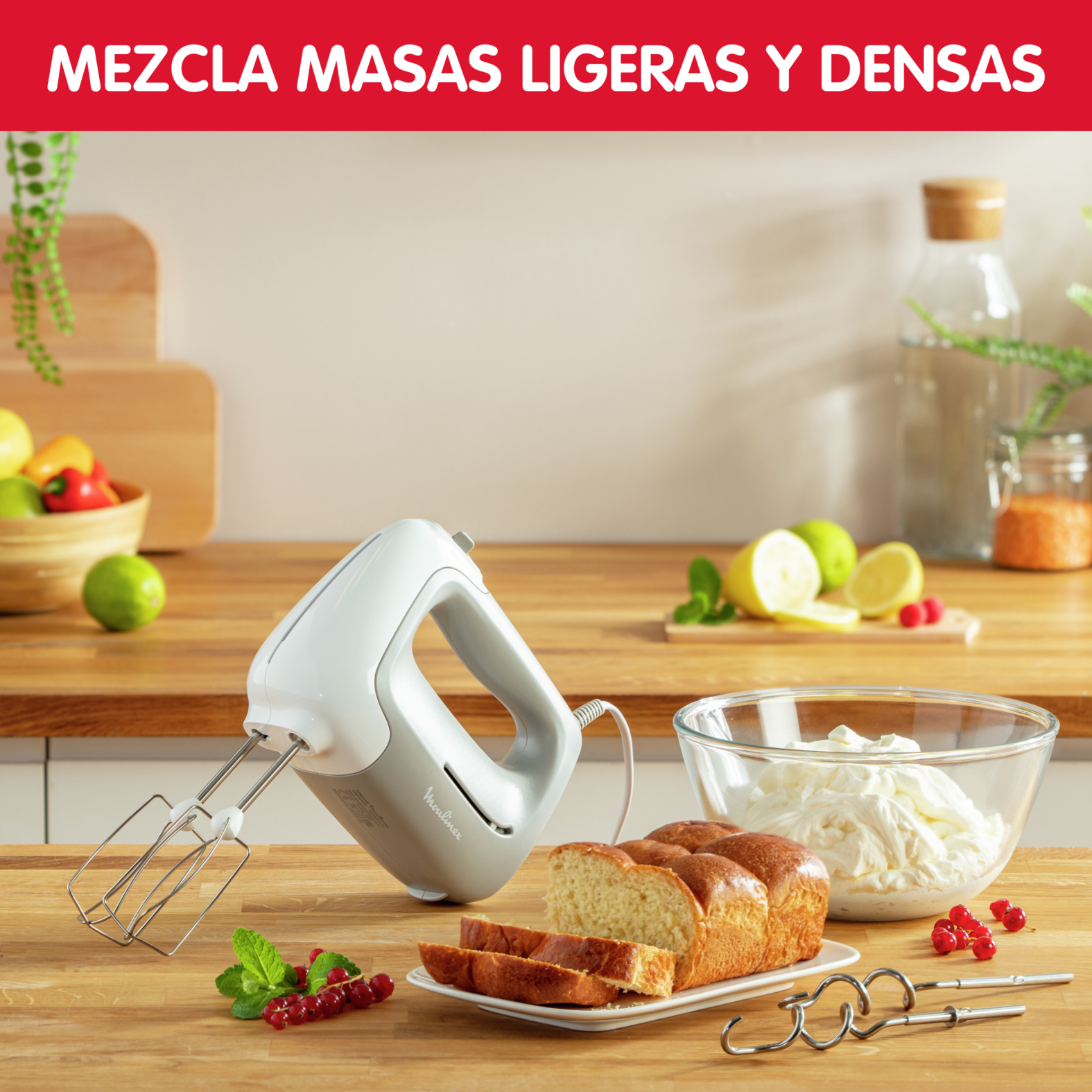 Una escena de cocina con una batidora, pan e ingredientes sobre una mesa.