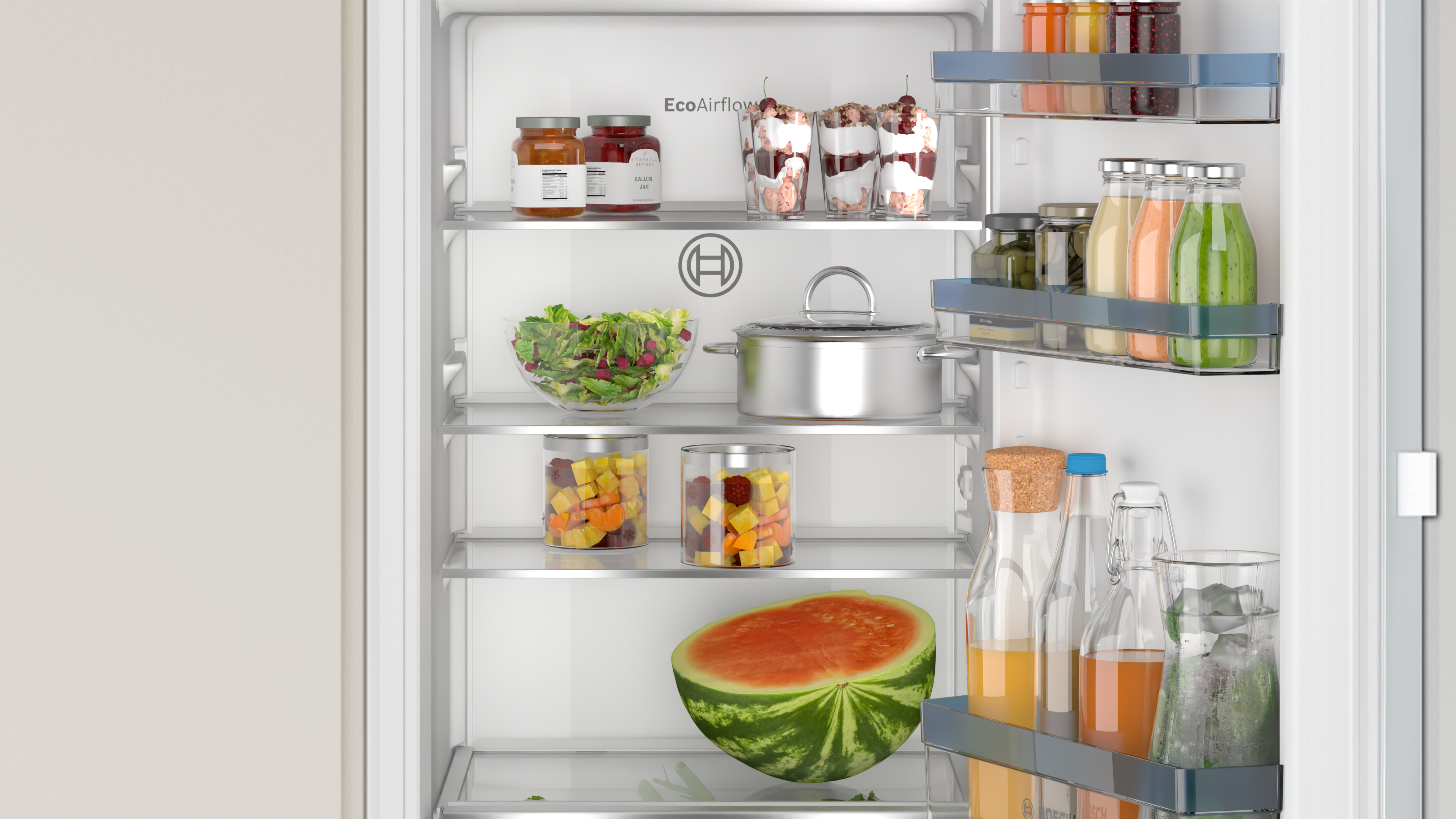 Open refrigerator with shelves. Contains jars, a bowl of salad, a watermelon half, and bottles.