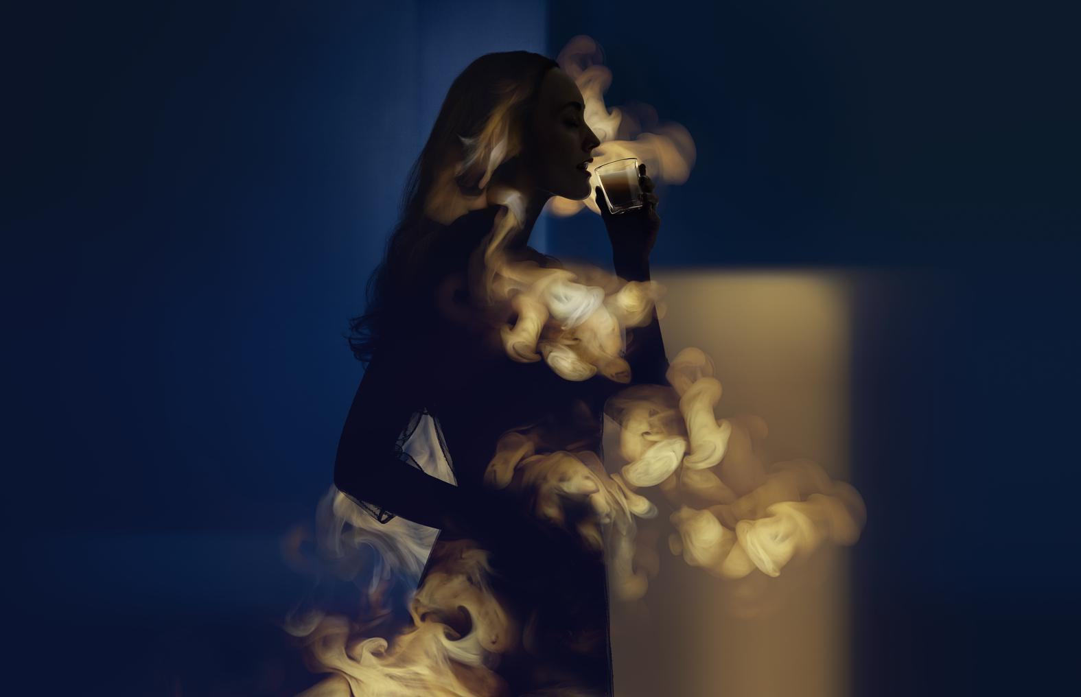 Frau in Silhouette, die ein Telefon hält, umgeben von einem rauchigen, verschwommenen Hintergrund.