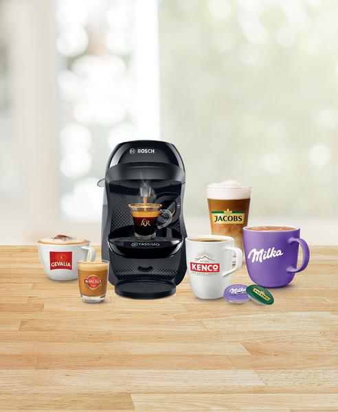 Kaffeemaschine mit verschiedenen Tassen. Auf einem Holztisch steht eine Kaffeemaschine mit verschiedenen Kaffeetassen.