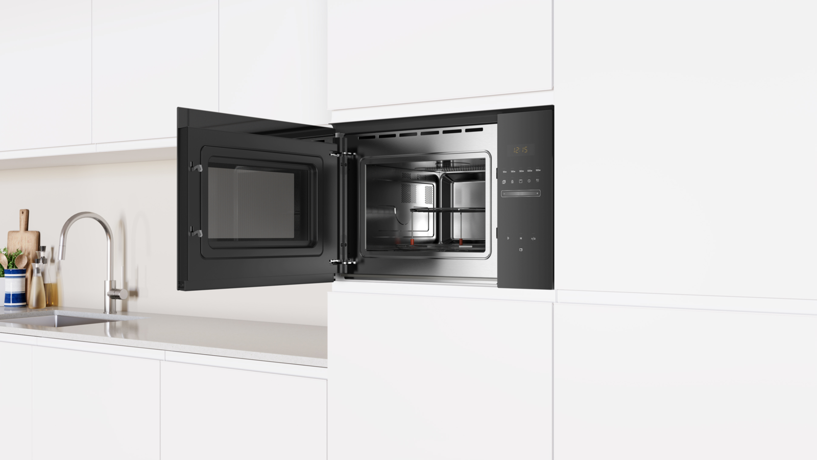 Horno microondas abierto, interior negro, con dos platos dentro, instalado en un armario blanco.