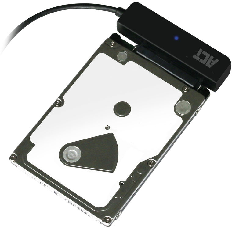 Disque dur connecté à un adaptateur noir. Le disque est argenté avec une étiquette blanche. L'adaptateur porte le mot ACT.