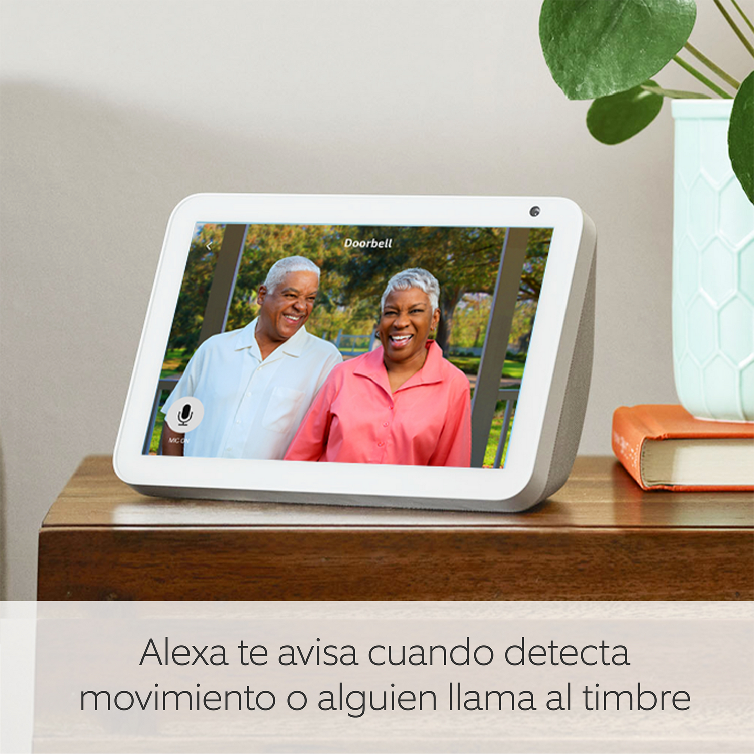 Una pantalla inteligente que muestra a una pareja de ancianos. El texto dice: Alexa te avisa cuando hay movimiento o alguien toca el timbre.