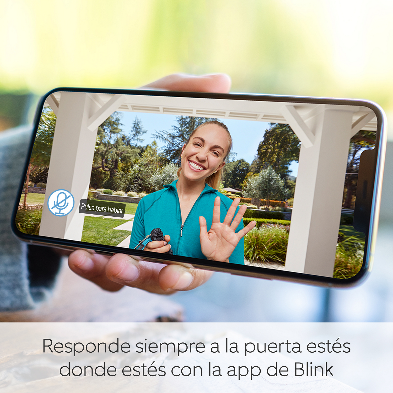 Persona sosteniendo un teléfono que muestra una videollamada con una mujer sonriente.