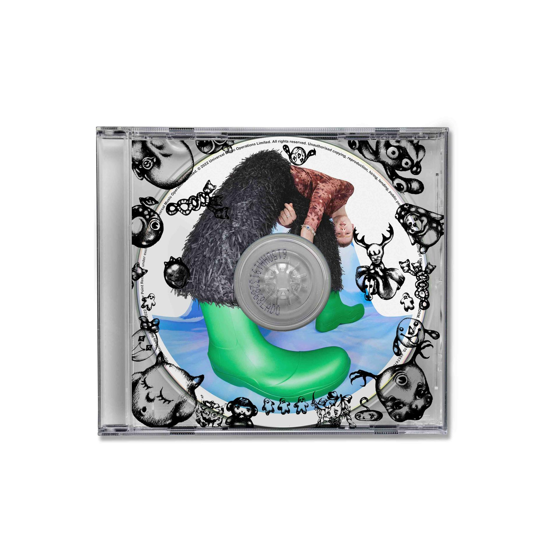 CD-Hülle mit einer Person in einem grünen Stiefel, in einem Cartoon. Die Disc hat Grafiken.