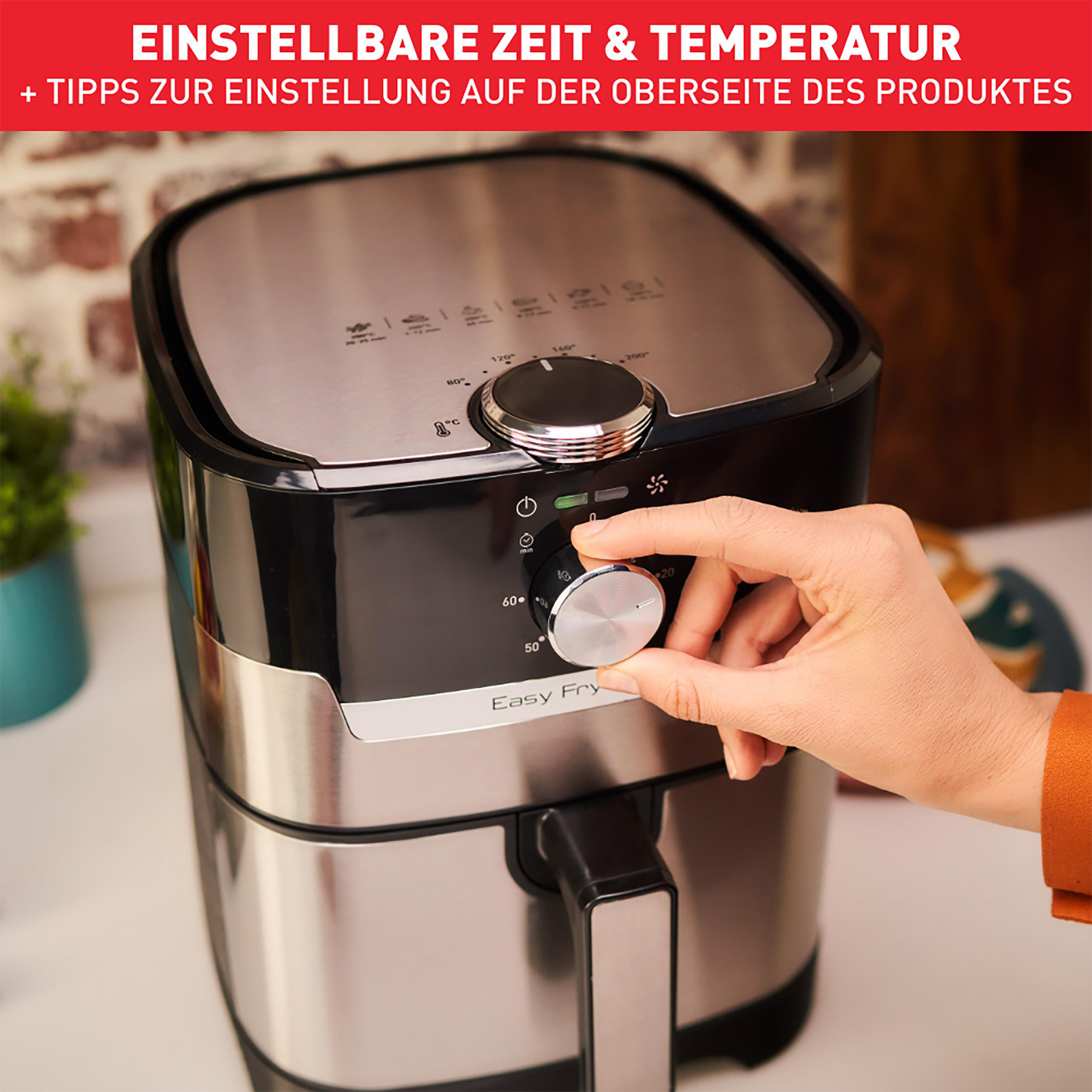 Person stellt den Timer eines schwarzen und silbernen Luftfritters ein. Schwarzer Griff, Drehknopf und Knöpfe.