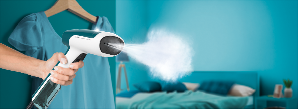 Nő Tefal ruhagőzölőt használ, kék ruhát gőzöl.