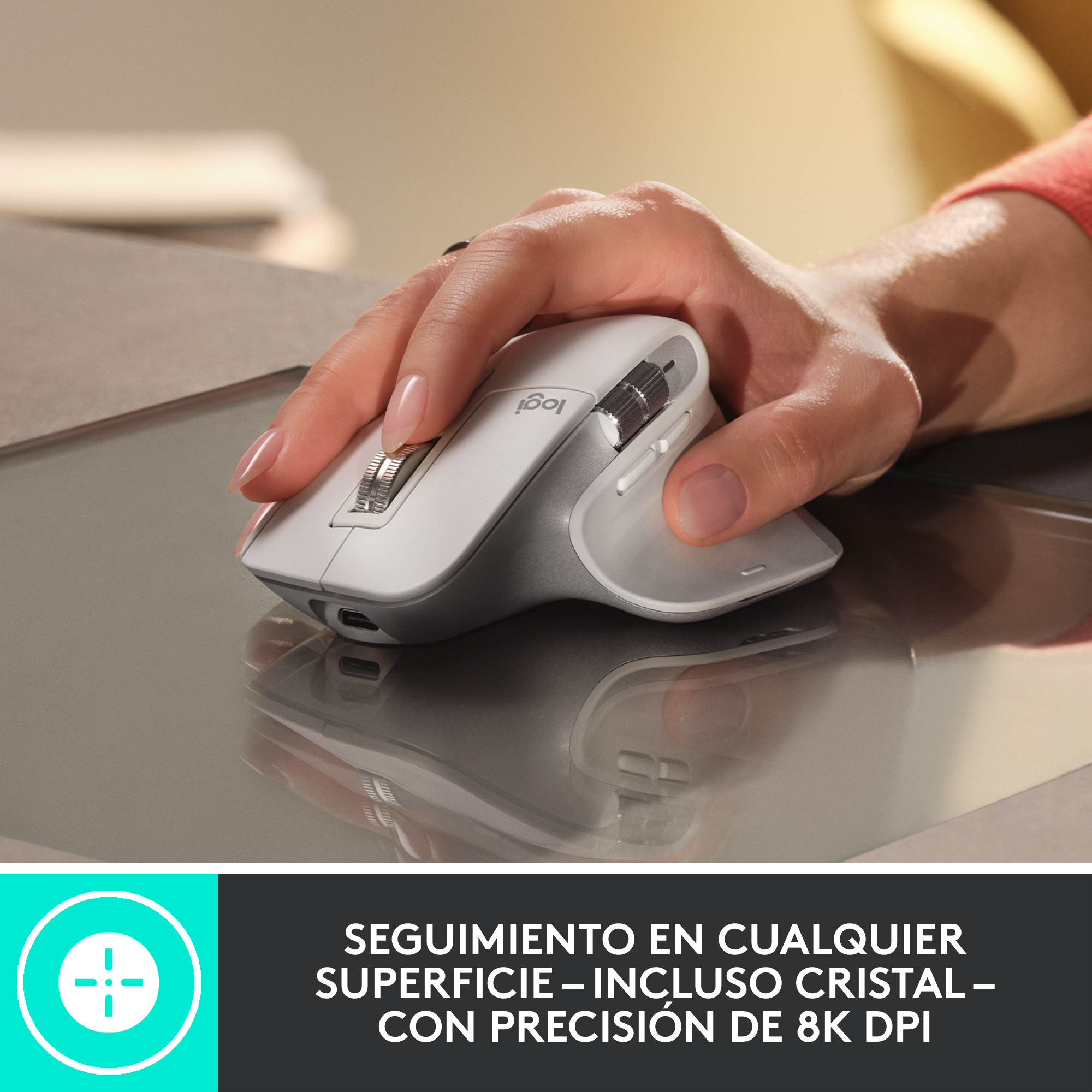 Una persona usando un ratón de ordenador blanco y gris sobre una superficie gris oscura.