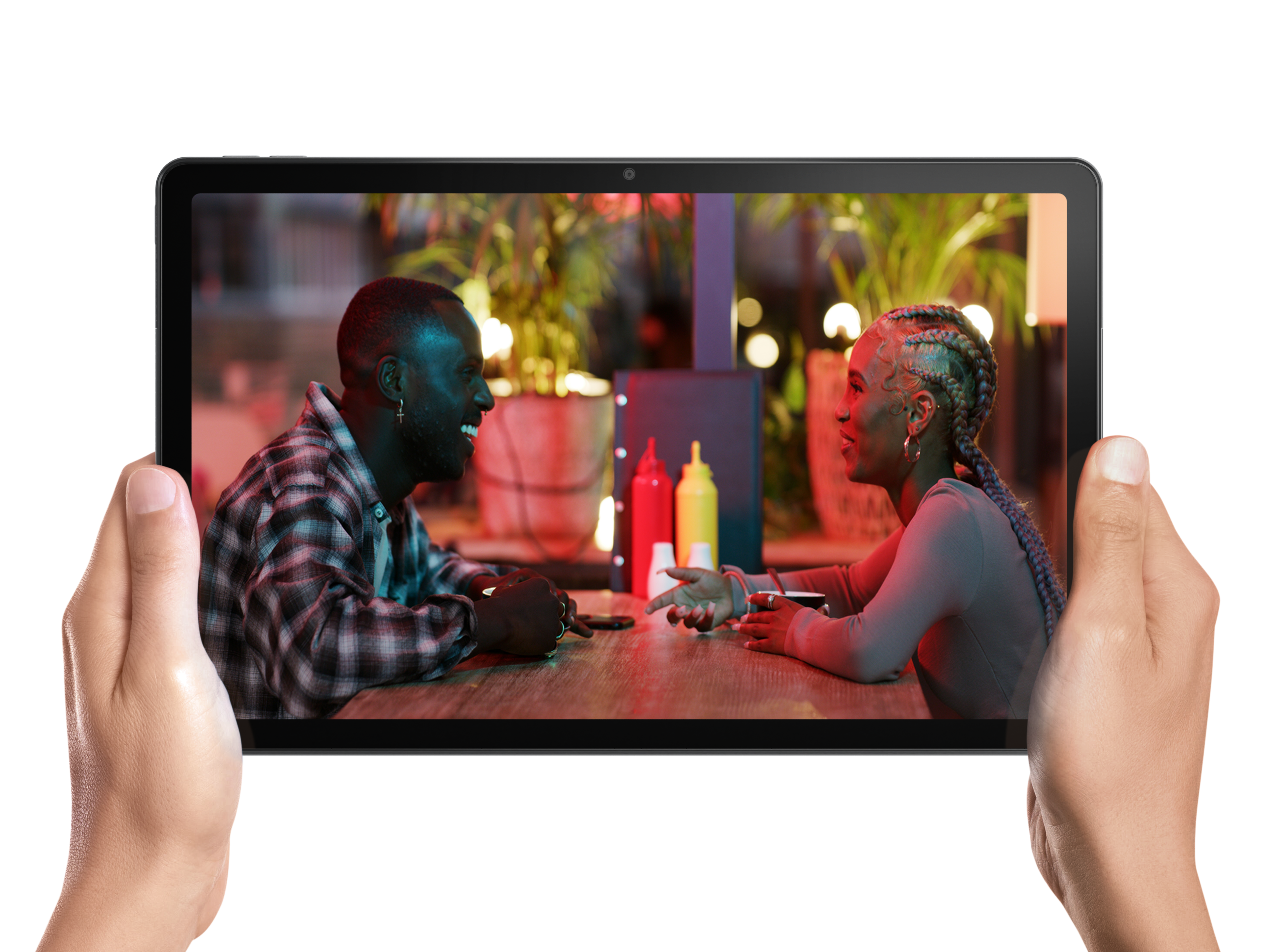Hände halten ein Tablet mit zwei Personen in einem Restaurant. Der Hintergrund ist eine verschwommene Restaurantszene.