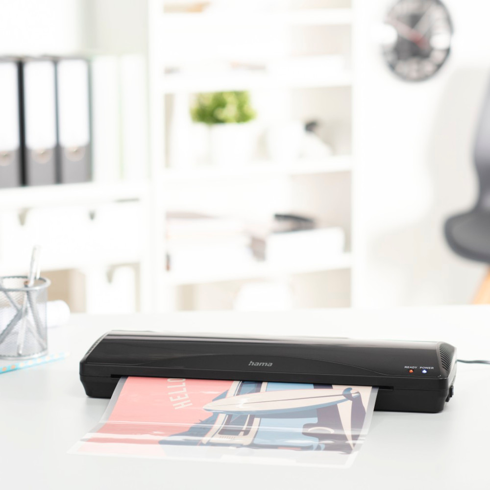 A black laminator with a poster inside. The Hama logo is visible.