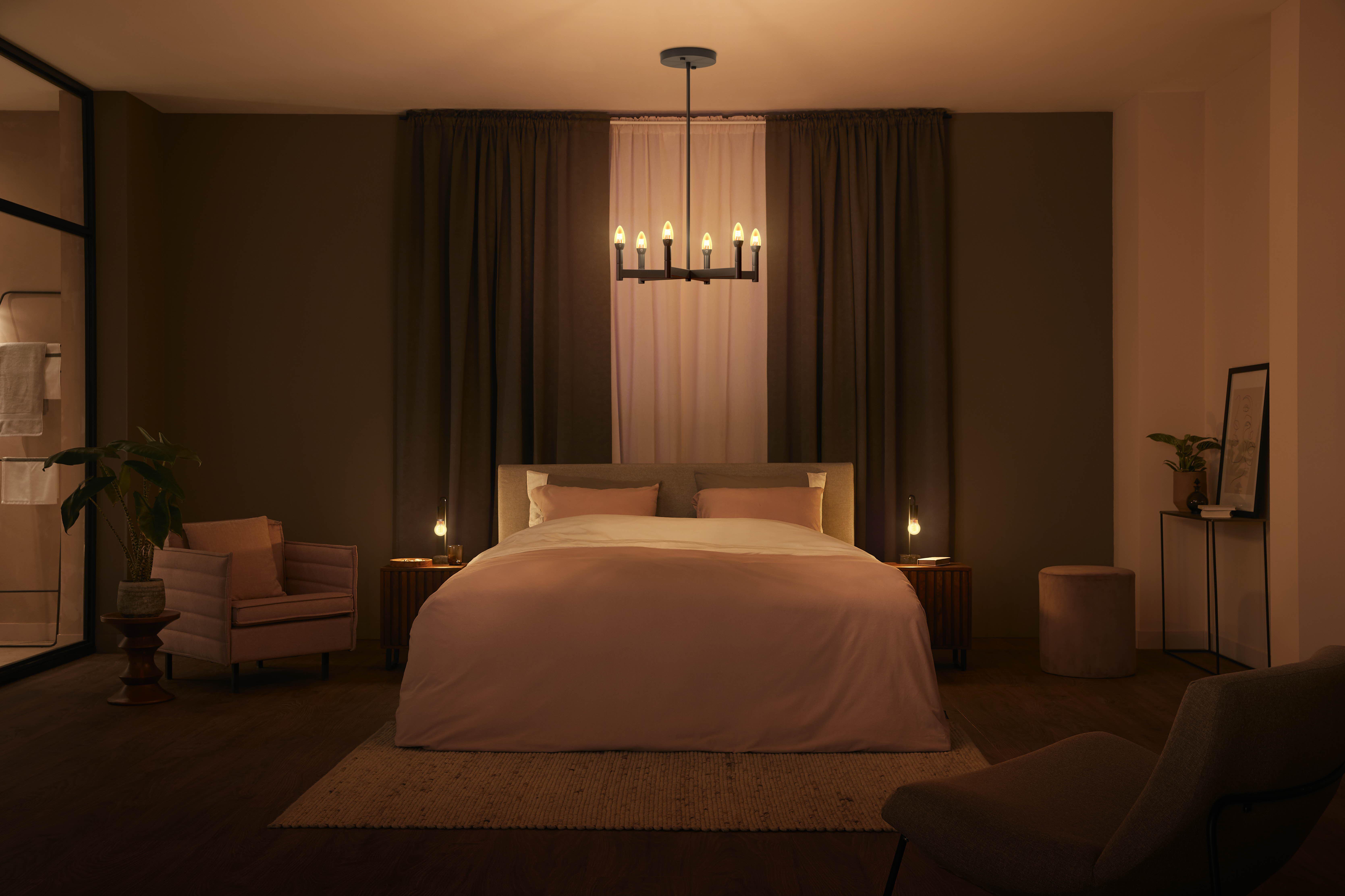 Schlafzimmer mit Bett, Lampen und Kronleuchter. Weiche Beleuchtung.