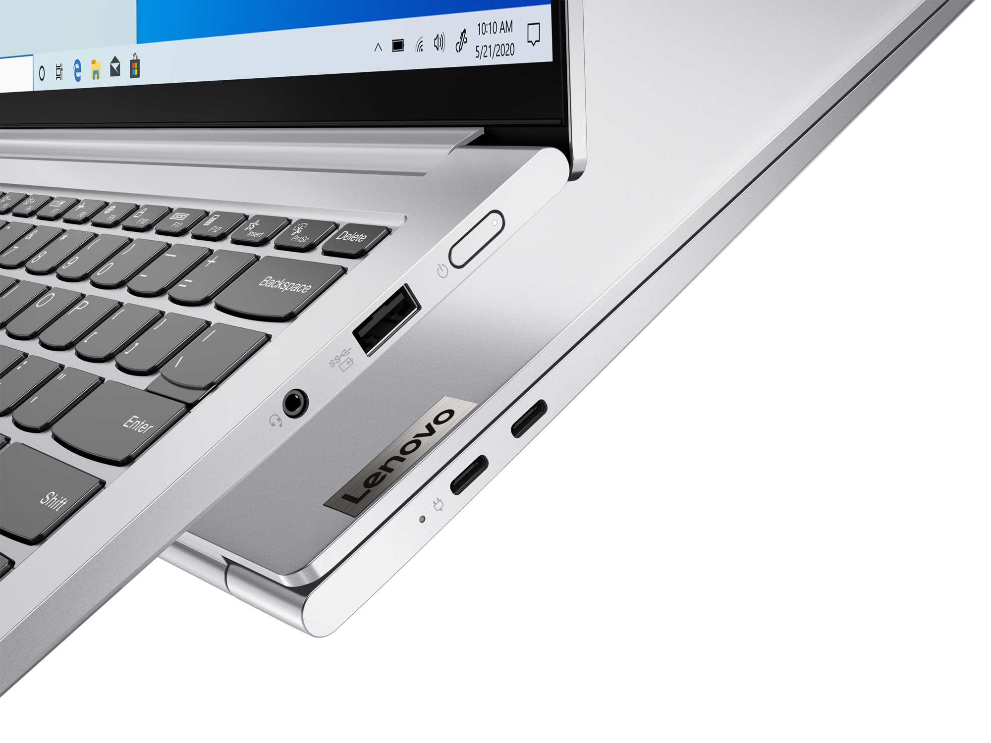 Silberner Laptop, Tastatur, Anschlüsse und Lenovo-Logo sichtbar. Schwarzer Hintergrund.