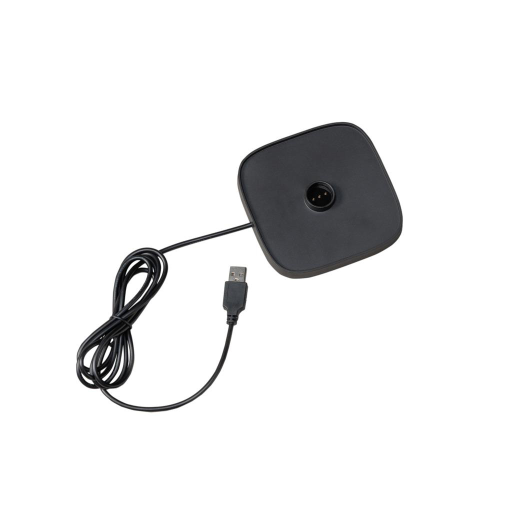 Eine schwarze Ladestation mit angeschlossenem USB-Kabel. Ein schwarzes Kabel ist mit der Basis verbunden.