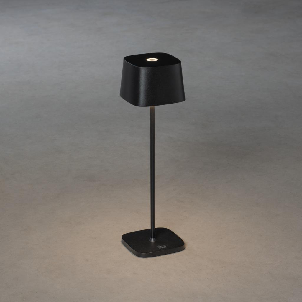 Schwarze, moderne, minimalistische Lampe auf einem Stiel, mit quadratischer Basis.