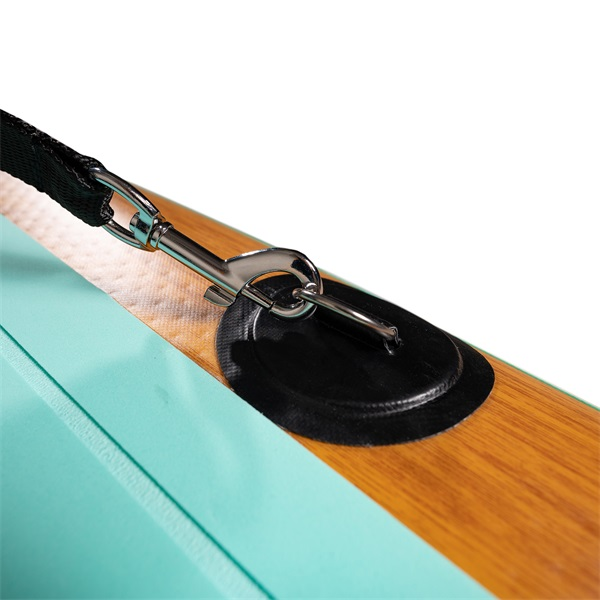 Közelkép egy paddleboard póráz rögzítéséről. Fekete heveder ezüst klipsszel a deszkához rögzítve.