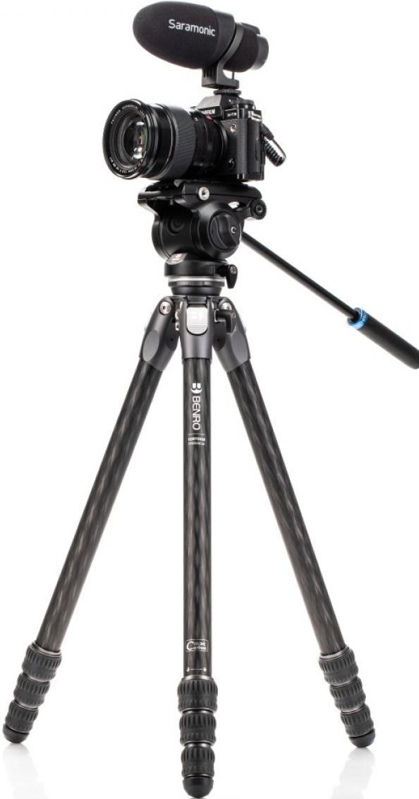 Appareil photo professionnel monté sur un trépied. Il a un microphone et est sur un fond blanc.