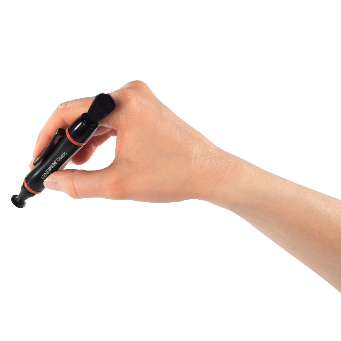 Main tenant un stylo d'objectif noir. Brosse noire en haut. Fond blanc.