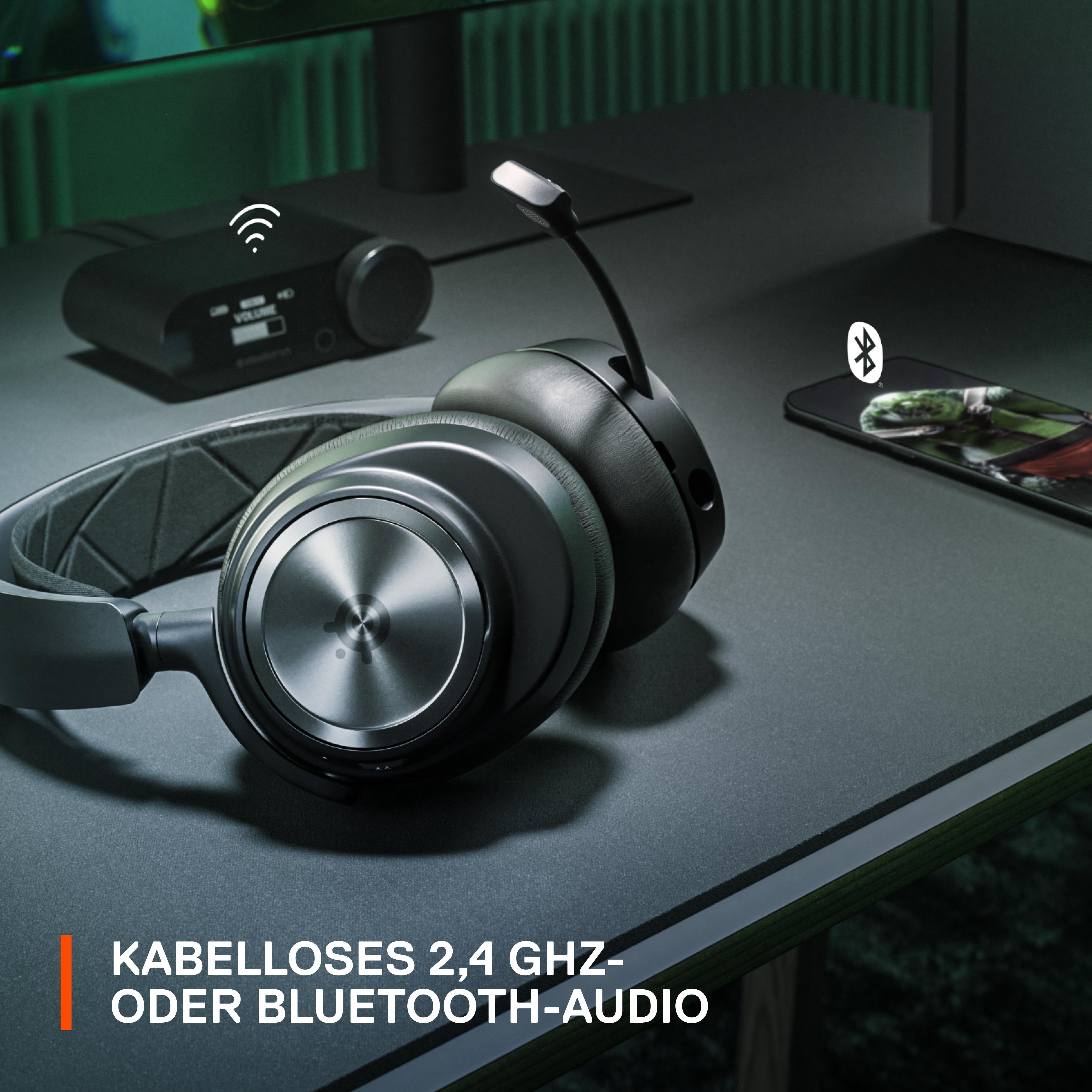 Schwarzes Headset auf einem Schreibtisch mit Smartphone und Lautstärkeregler.