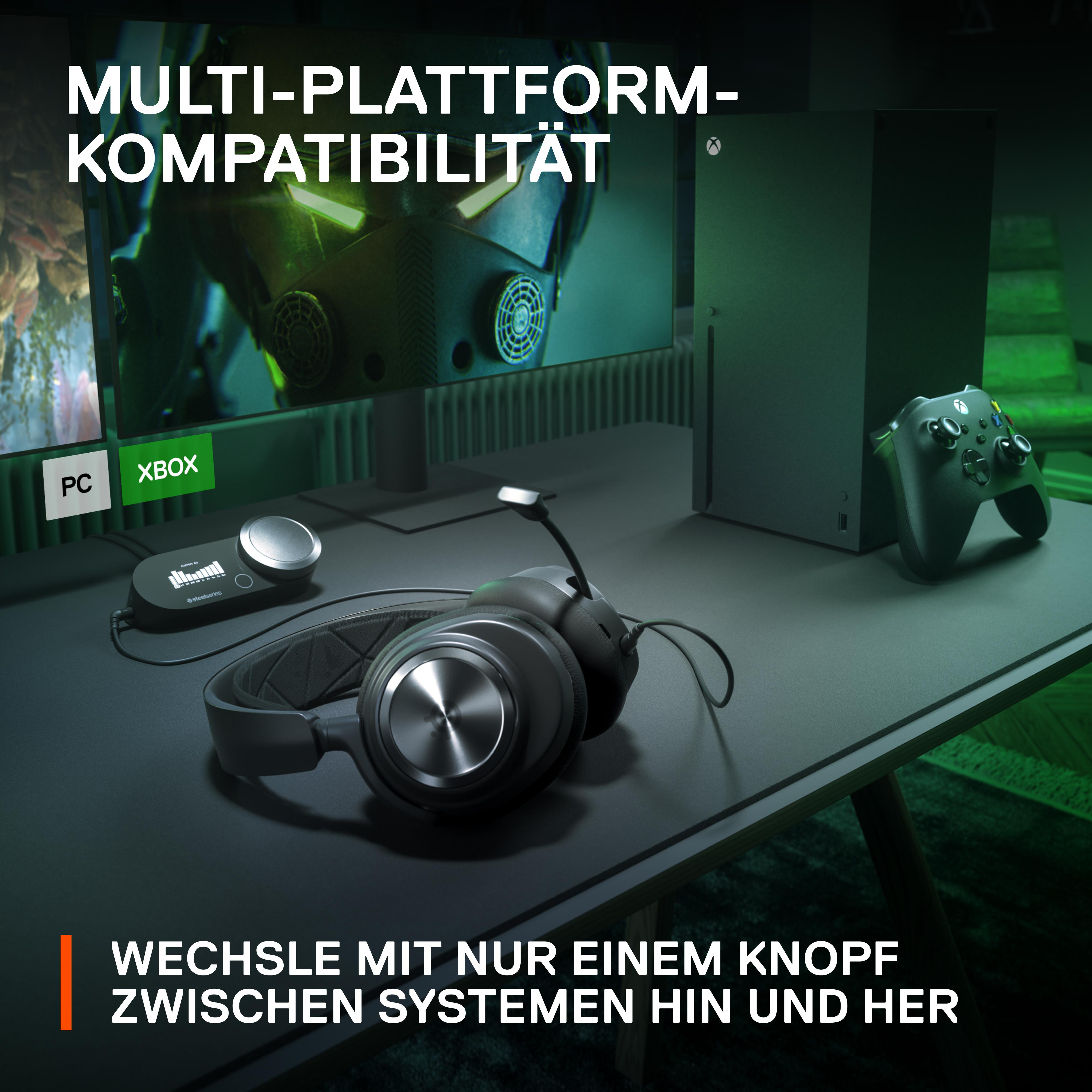 Gaming-Setup mit Kopfhörern, PC und Xbox-Konsole. Die Szene zeigt einen Schreibtisch und einen Monitor.