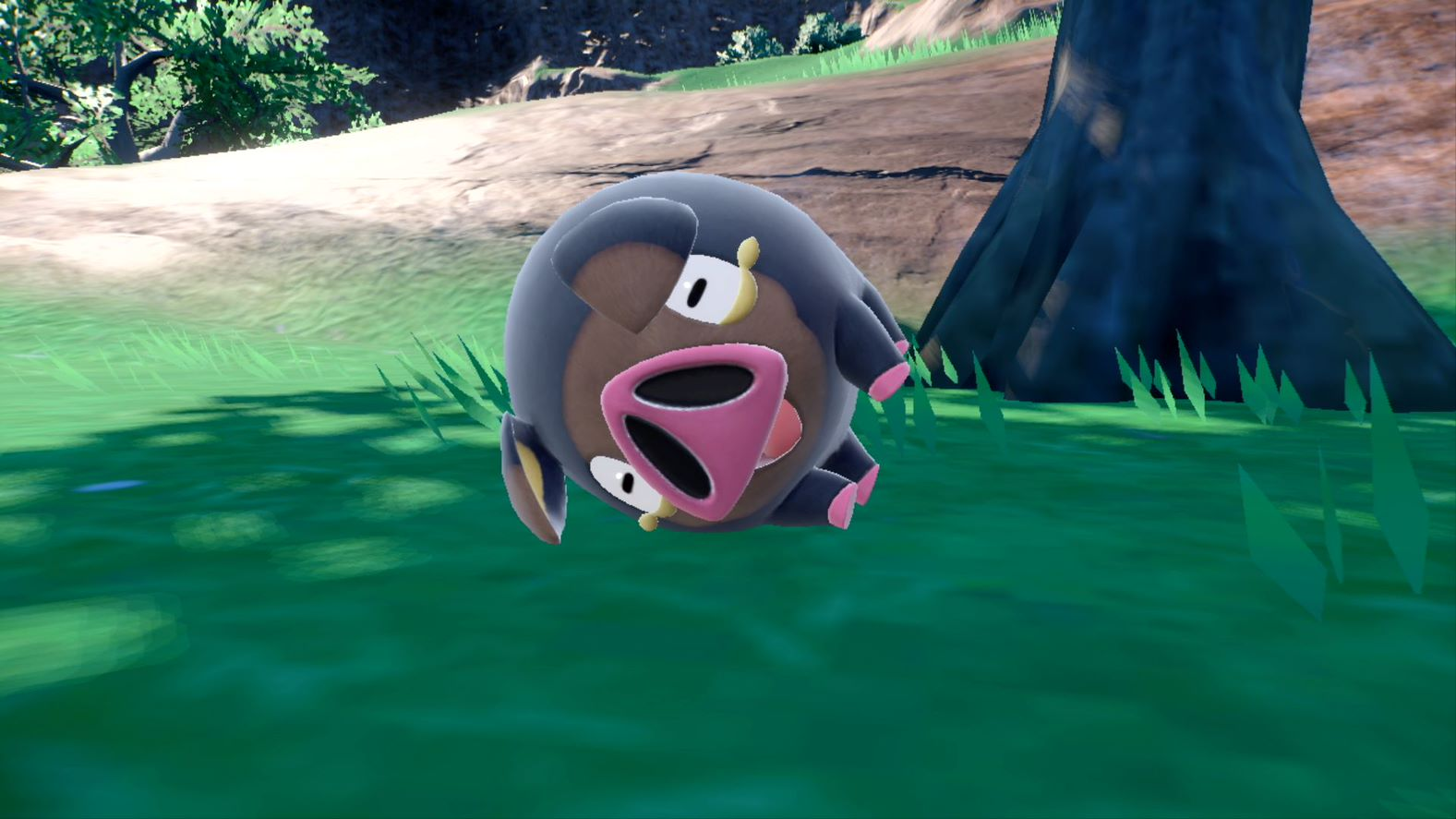 A cartoon pig lying in grass, with a dark head and pink mouth.