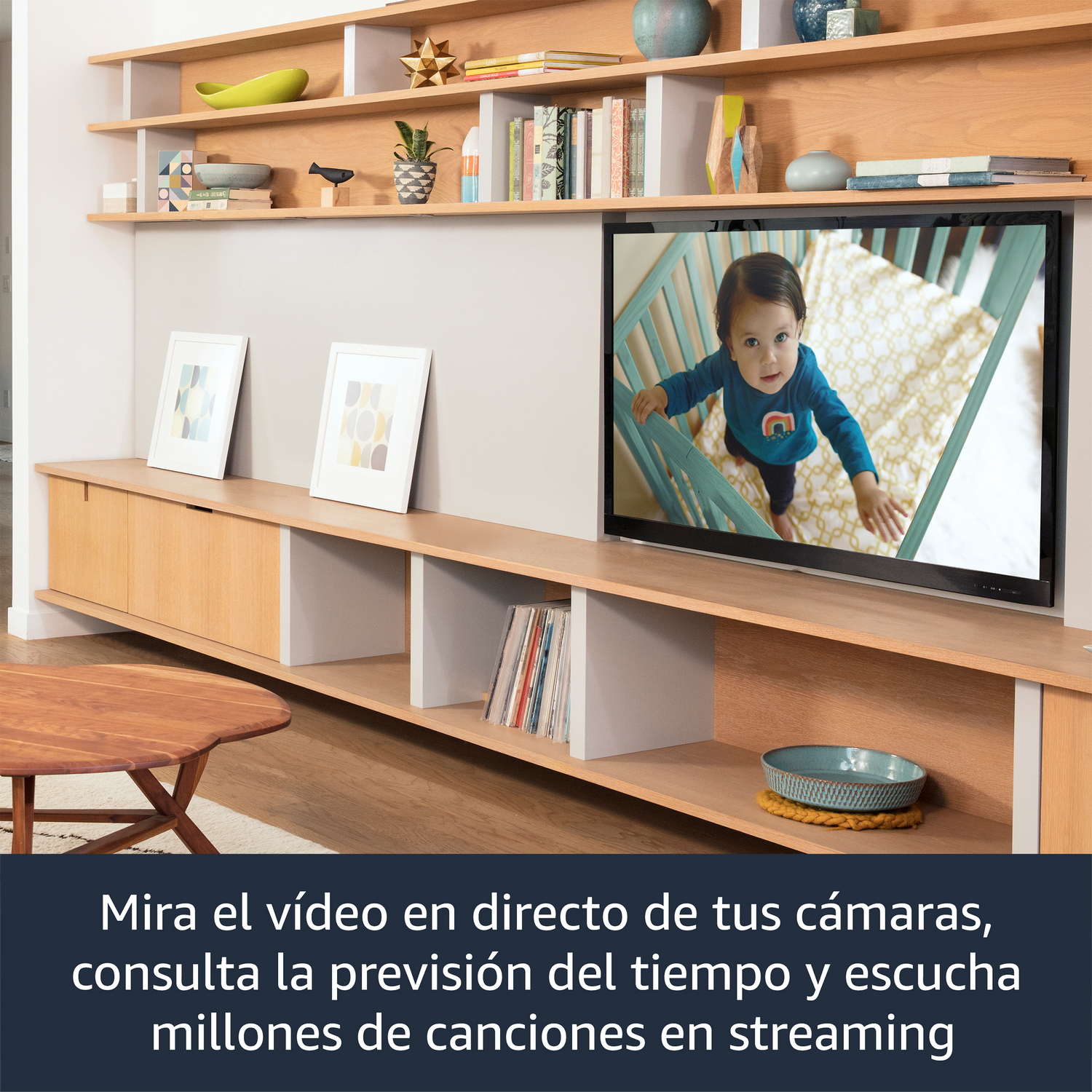 Salón con TV mostrando un bebé, estantería con libros, mesa de madera.