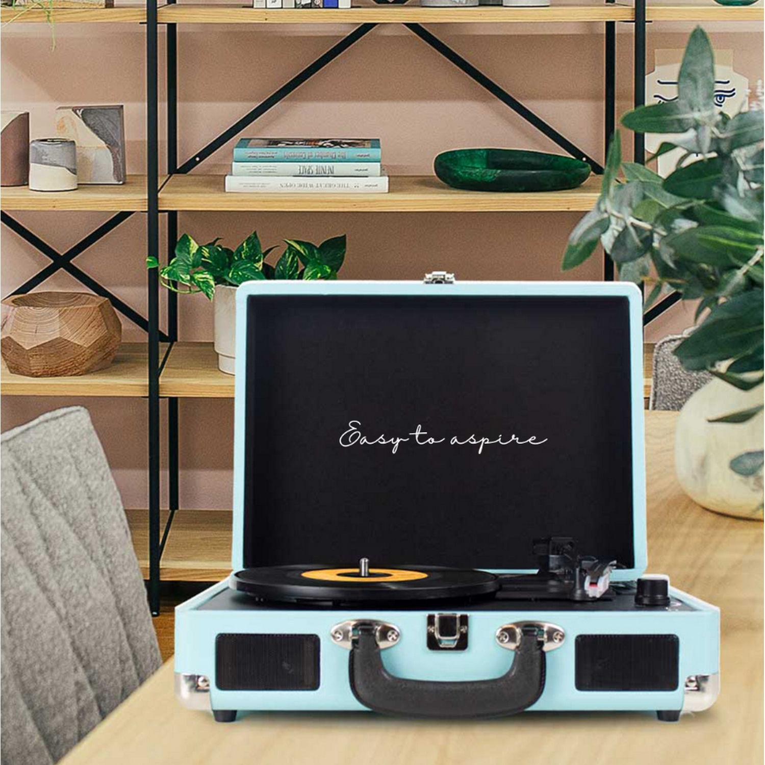Tocadiscos turquesa con tapa abierta y las palabras 'Easy to aspire' escritas.